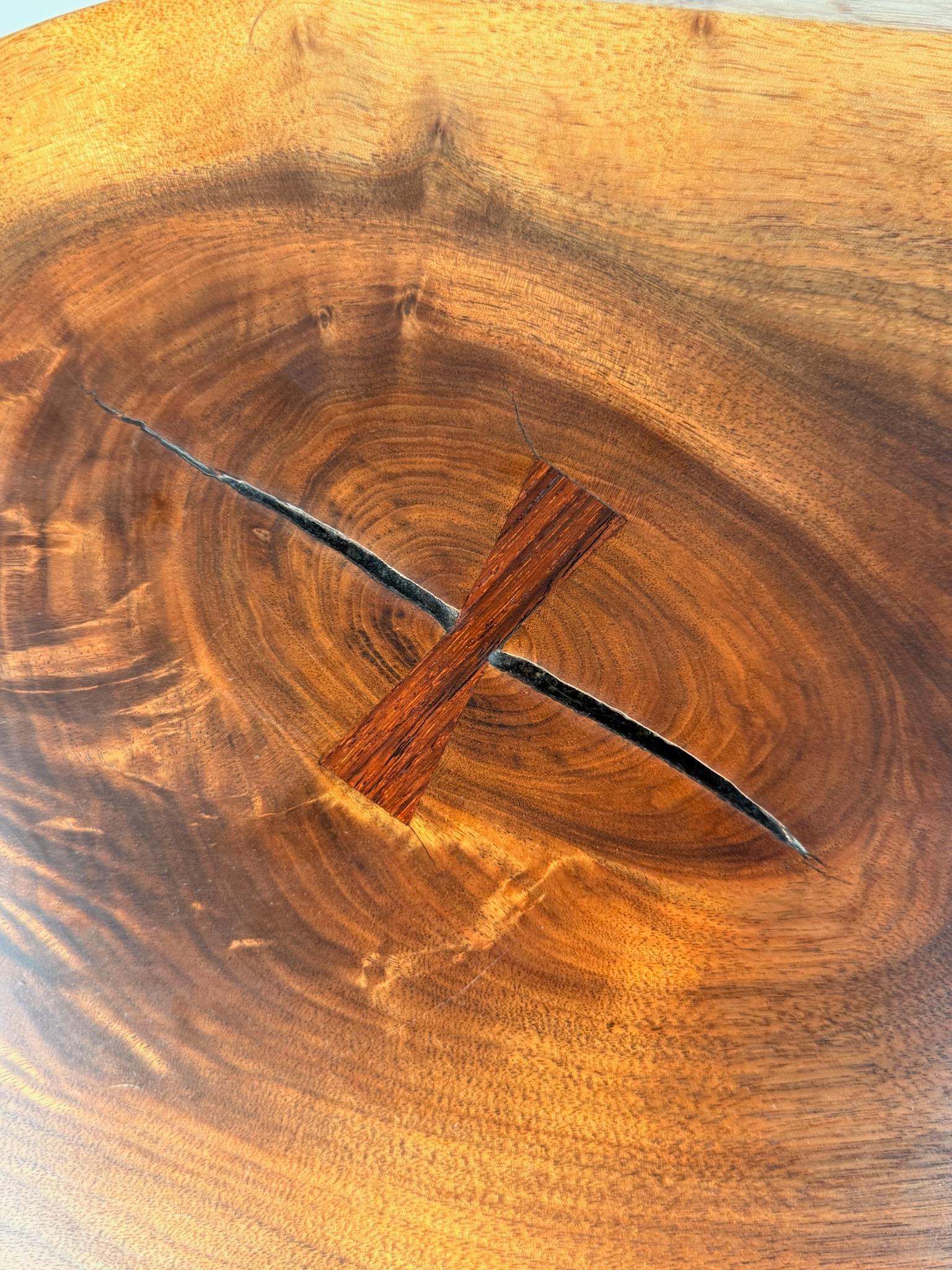 This rare and completely original George Nakashima coffee table is a poetic example of the master’s ability to honor the soul of the wood. Hand-built from a single slab of English Walnut, the surface shimmers with remarkable chatoyancy—a