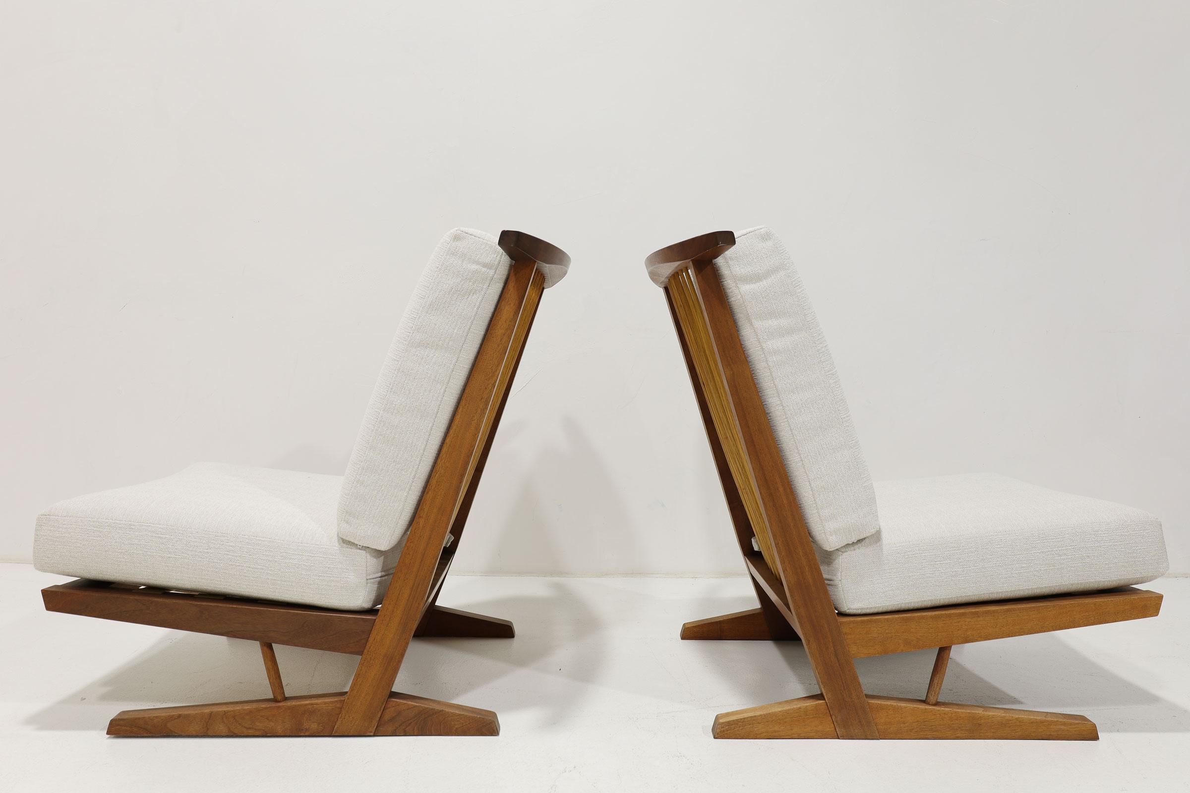 A beautiful pair of Conoid Lounge chairs by George Nakashima. Made by the only authorized manufacturer of Nakashima furniture outside of the United States, Sakura Seisakusho in Takamatsu, Japan. Cushions reupholstered in Holly Hunt. 