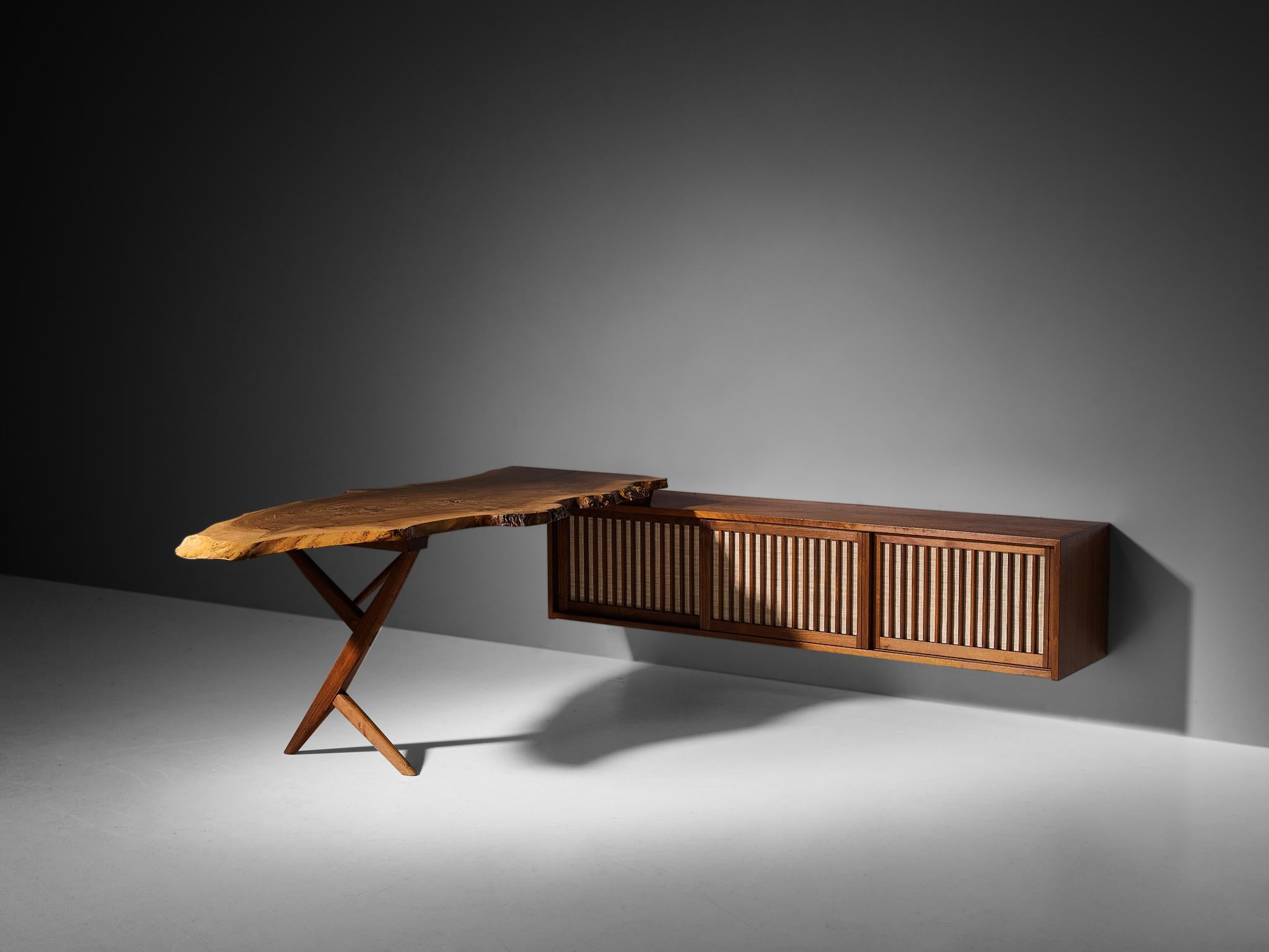 George Nakashima, desk with sliding-door wall-mounted cabinet, American black walnut, English walnut, pandanus cloth, United States, 1960

With regard to its essential form, material use, and woodwork, this unique combination of desk with