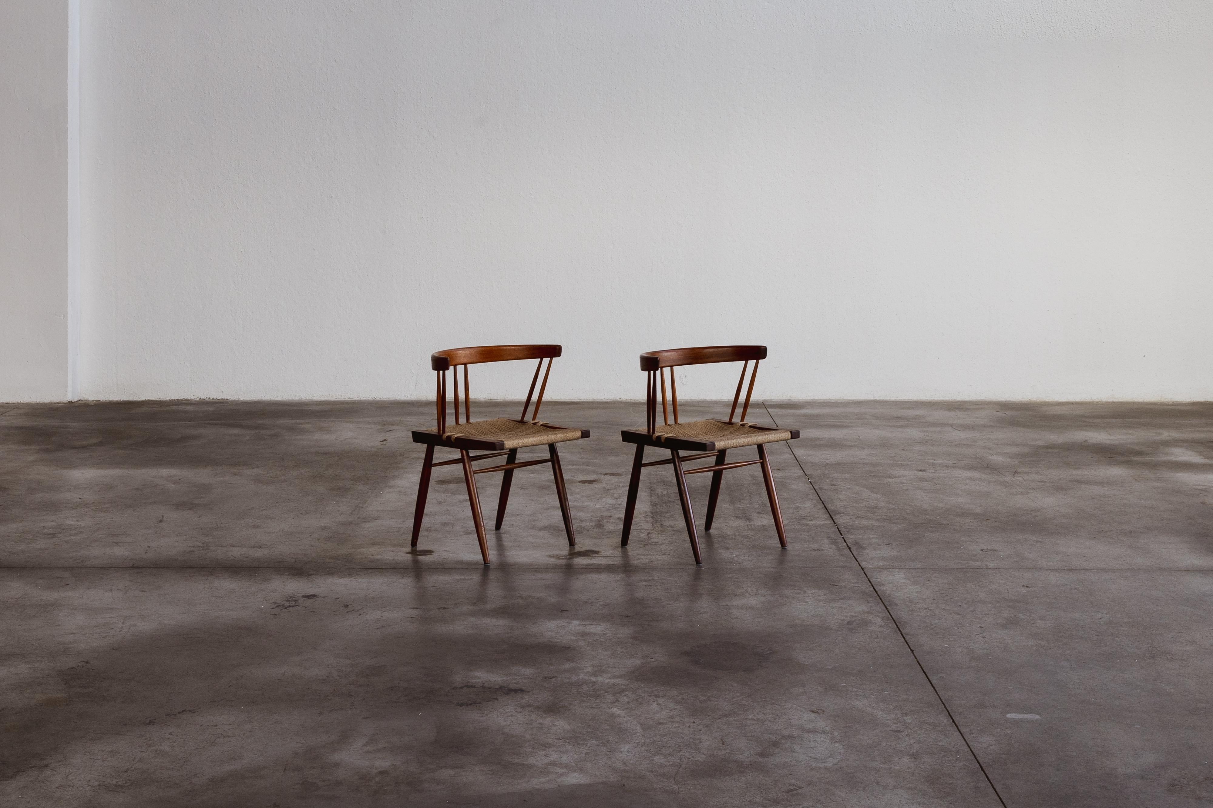George Nakashima dining chairs, seagrass and wood, USA, 1947, set of two.

George Nakashima designed these dining chairs in 1947, embodying a fusion of traditional Japanese woodworking and modernist design. Crafted from American black walnut, they