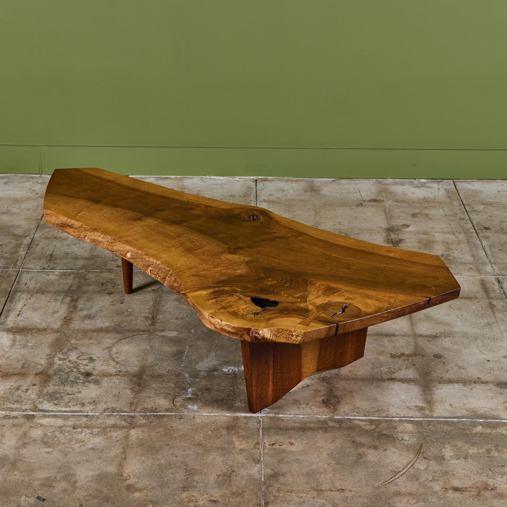 Tavolino da caffè dell'artigiano americano di metà secolo George Nakashima. Questo tavolo in noce inglese, risalente al 1971, è caratterizzato da un piano a lastre con supporto a un solo mandrino e una base a lastre con bordo vivo. Verificato dalla
