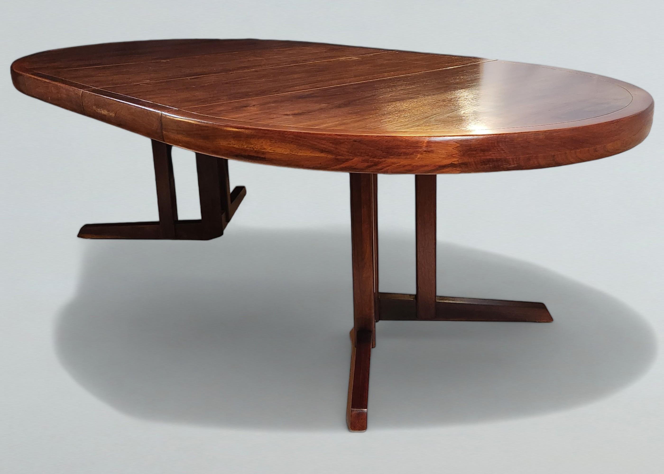 An extendable walnut dining table by George Nakashima for Widdicomb Furniture Company from 1959.
A line of bookmatched veneers encased by a 3 inch deep carved and finger joined solid walnut edge gives the top of the table an interesting contrast.