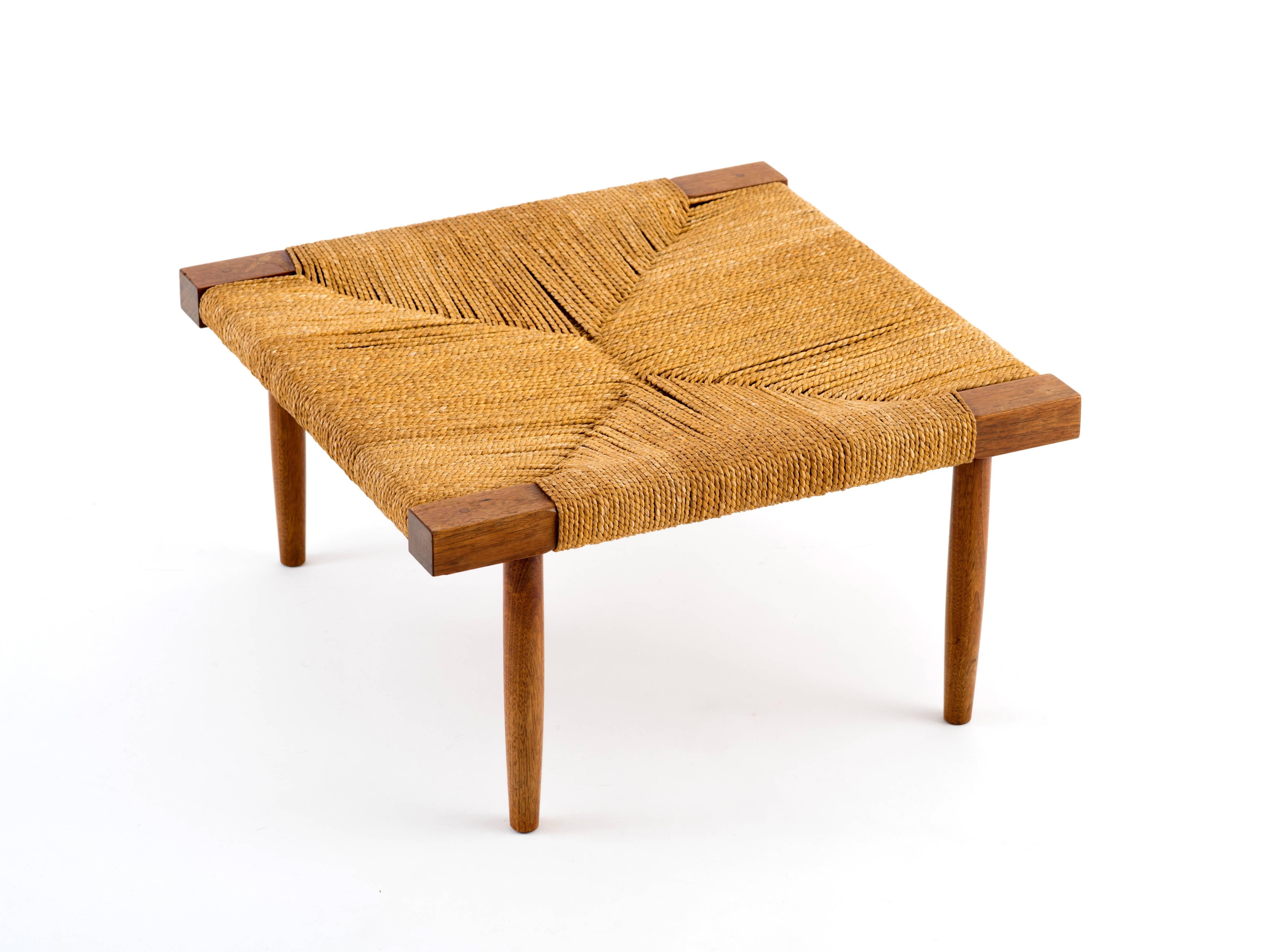 A low stool or ottoman in walnut with grass rope seat by George Nakashima, circa 1965. This design is both scarcer and larger than the more commonly-seen 12.5 inch height stool with splayed legs and it's in remarkable condition, particularly the