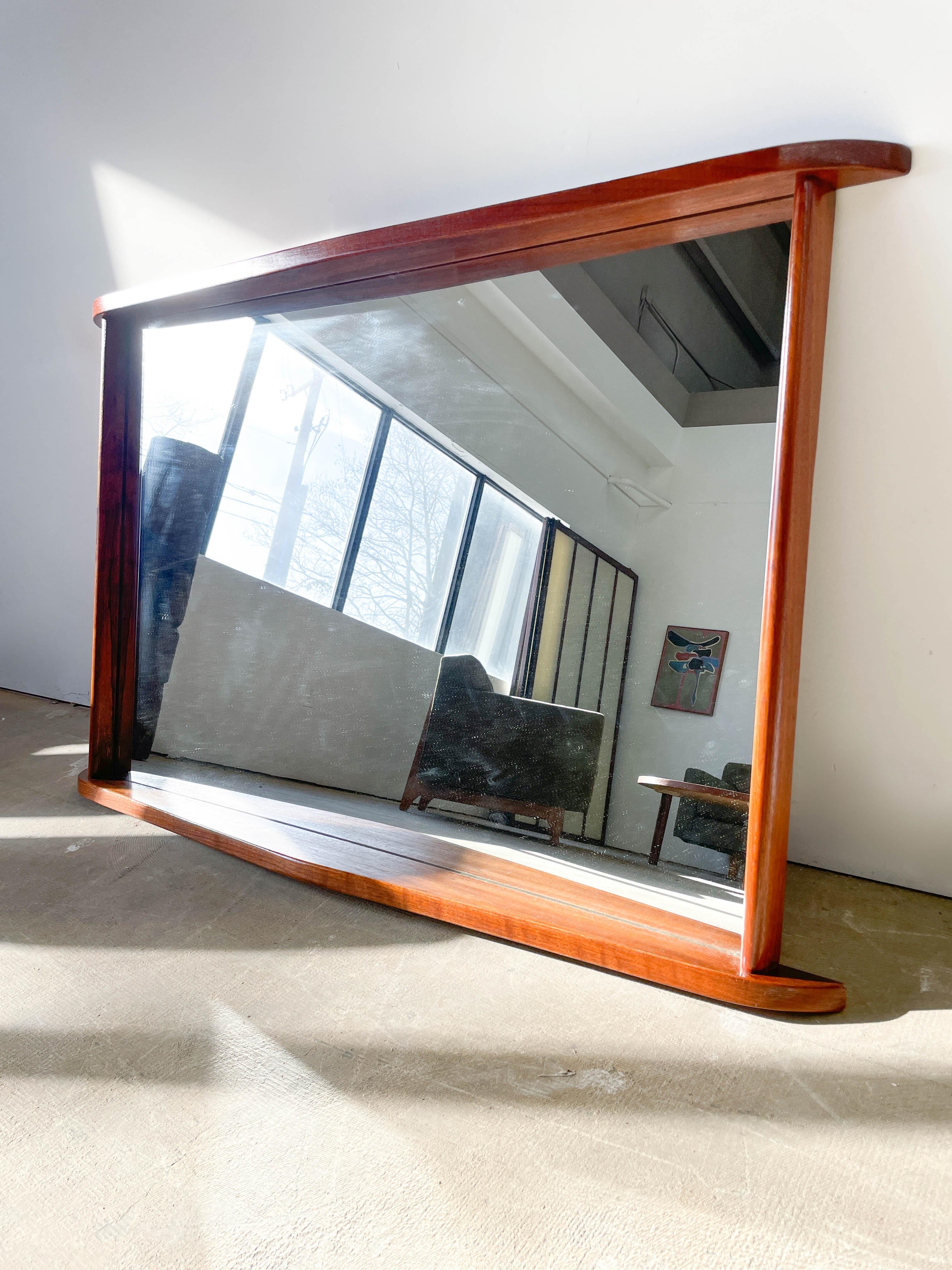Stunning vintage sculpted walnut framed mirror attributed to George Nakashima for his Origins collection for Widdicomb-Mueller, 1958-1964. This mirror incorporates Nakashima’s distinctive organic modern forms on the upper and lower edges and his