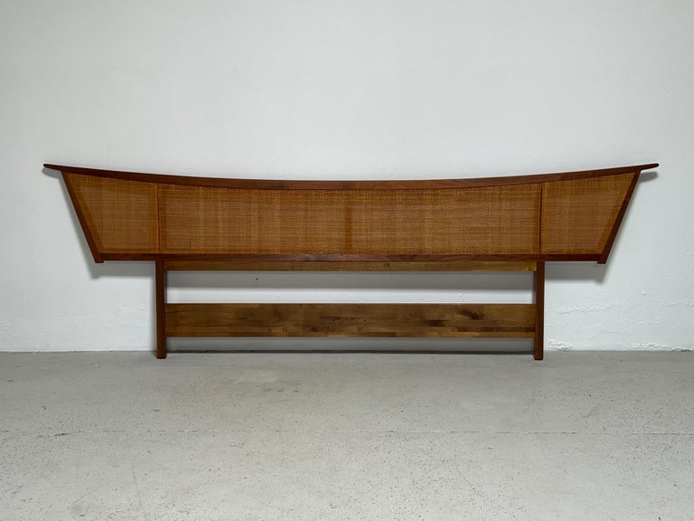 A large kingsize cane and walnut headboard designed by George Nakashima for Widdicomb. Matching nightstands and dresser available separately.