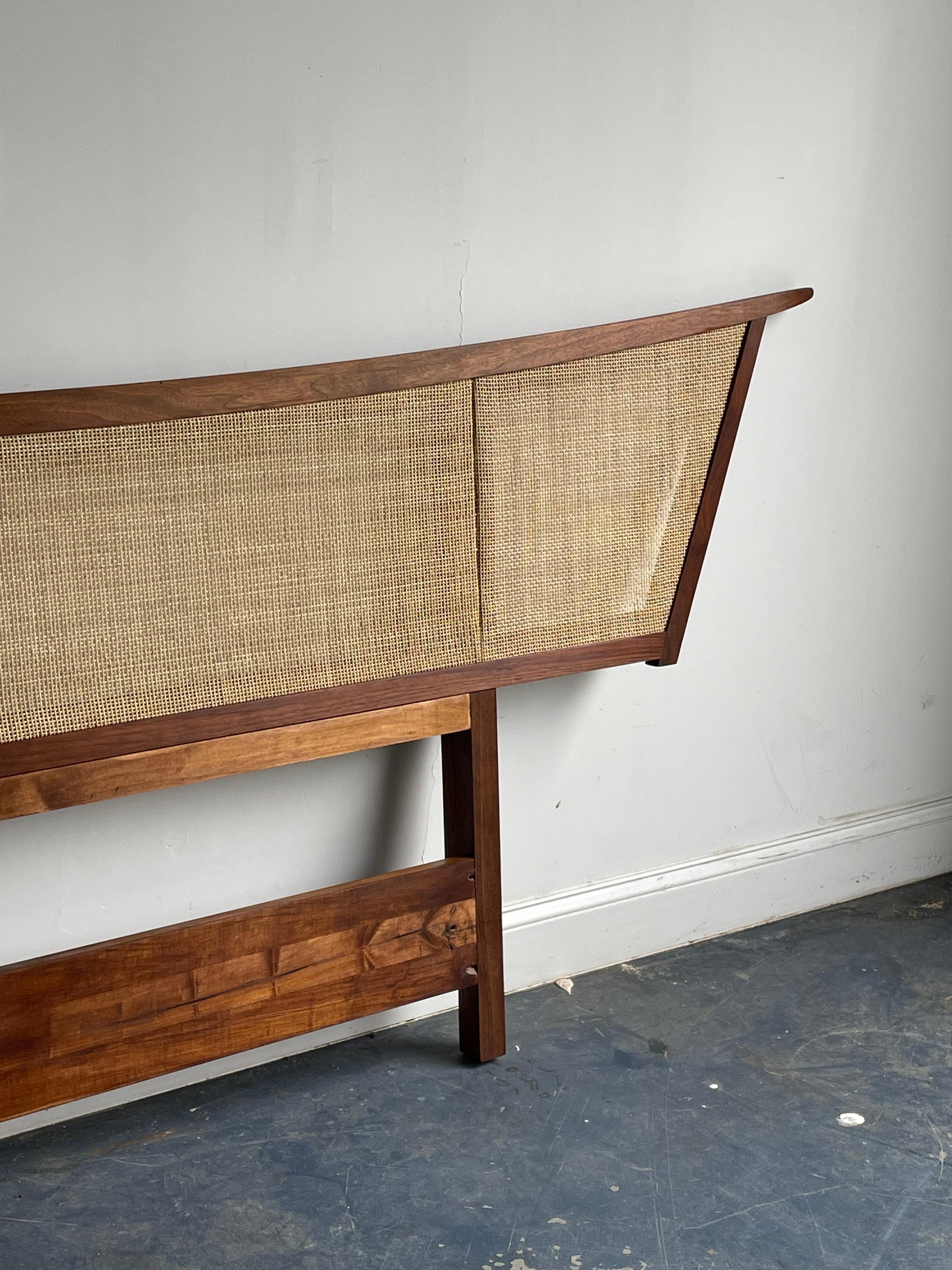 Large Kingsize headboard designed by George Nakashima for Widdicomb furniture. Piece was produce in 1961 per the date shown (3/1961). Headboard has been newly refinished and caned. Some wear around the placement of the bed frame brackets will go.