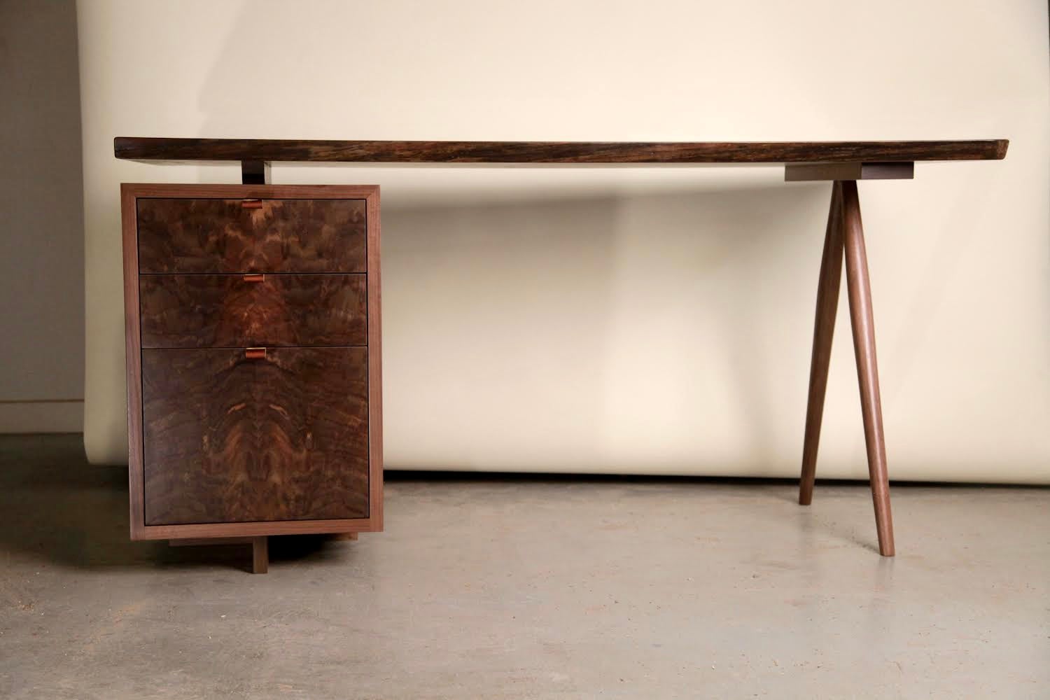 A walnut desk inspired by George Nakashima’s desk design of the late 1950’s. The desk is built in solid walnut with an exceptional live edge walnut slab top complimented by Wenge butterfly’s. The spindle legs are turned by hand in the shop to have