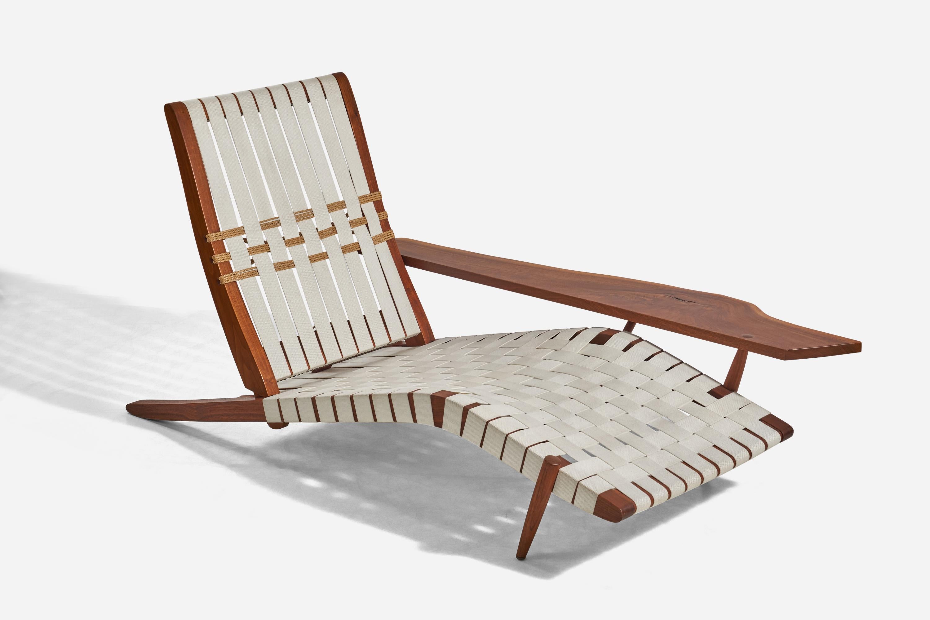 Langer Stuhl aus amerikanischem Schwarznussholz und Baumwollgewebe, entworfen und hergestellt von George Nakashima, USA, 1960er Jahre.

Mit einer großen, für Nakashima typischen Armlehne mit Noppendetails und freier Kante.