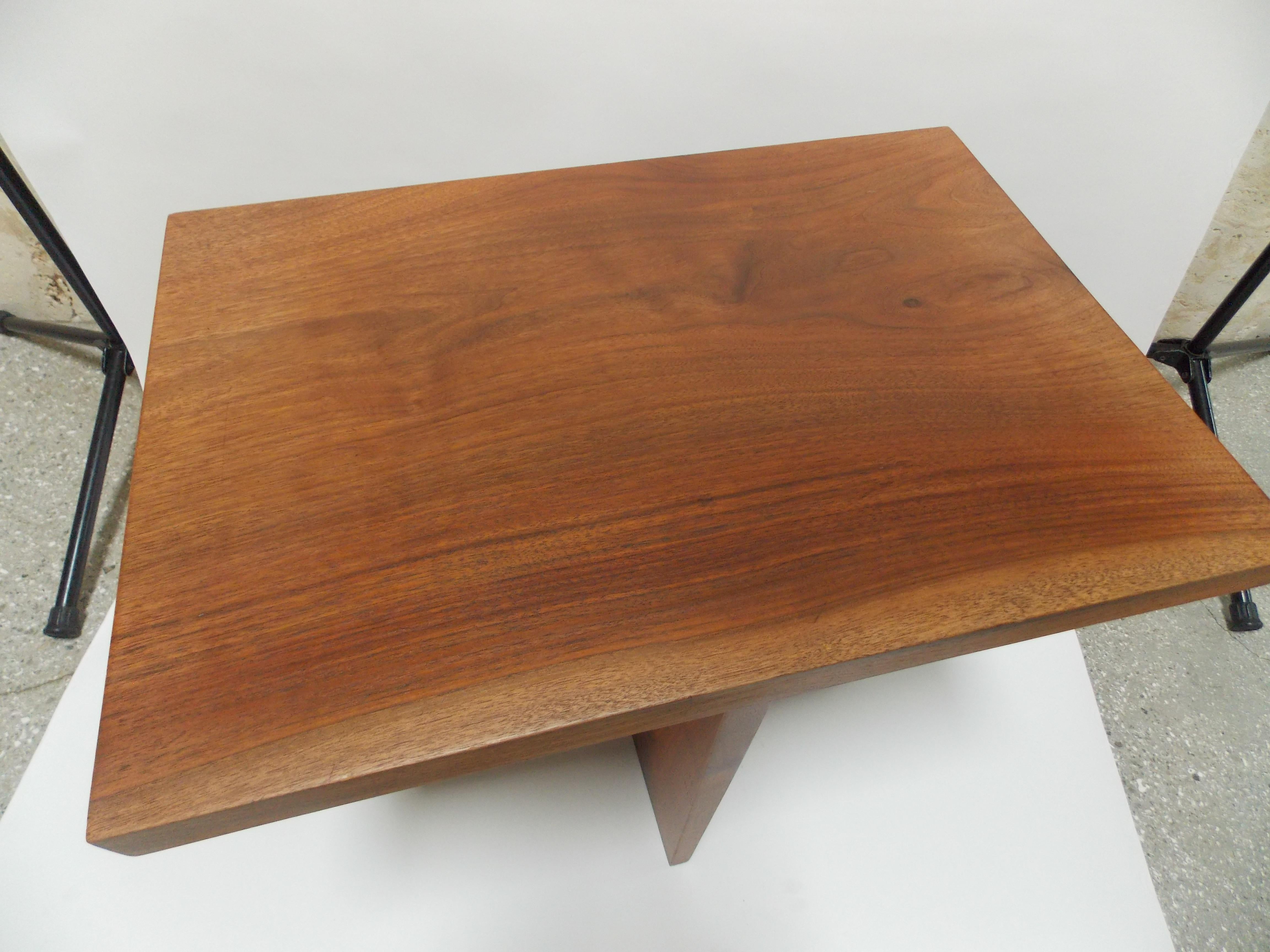A walnut table designed by George Nakashima
clients name on underside of table top.
expressive grain on both table top and center pedestal.