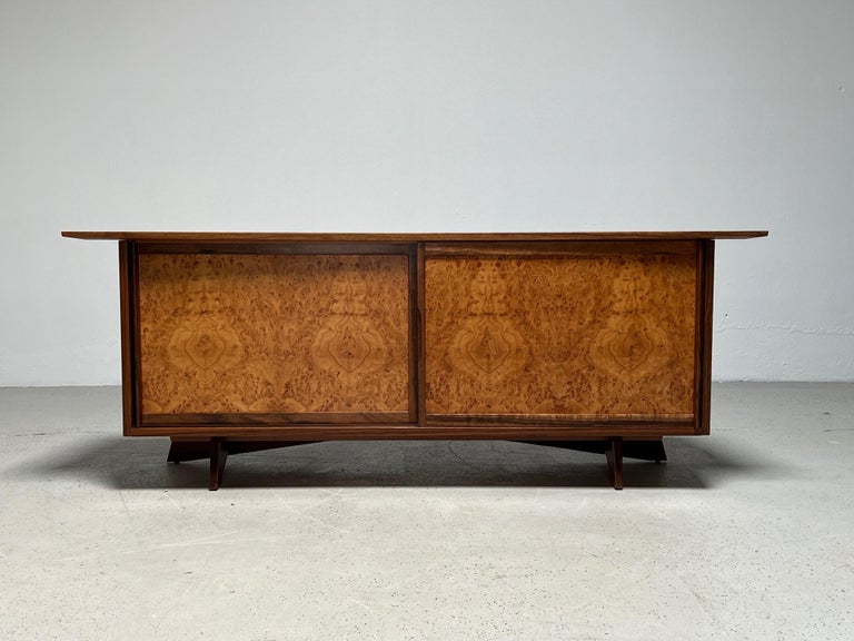 A beautifully restored walnut cabinet with sliding doors in figurative Carpathian Elm. Designed by George Nakashima as part of his Origins line for Widdicomb in 1959.