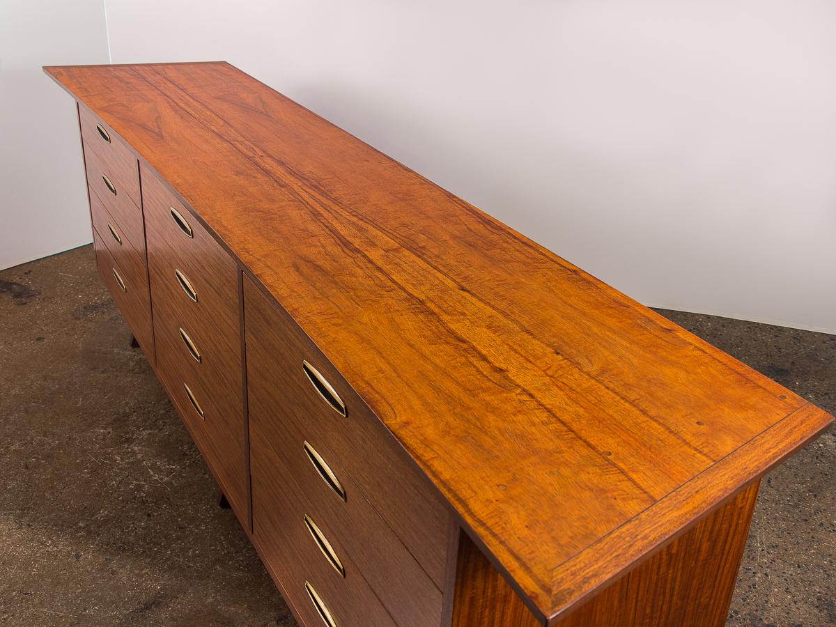 George Nakashima Origins triple dresser for Widdicomb. Distinct, attractive wood grain that is stunning on the bowed top and all sides. Condition is excellent. Original brass pulls are beautiful on all twelve drawers. Top two rows of drawers have