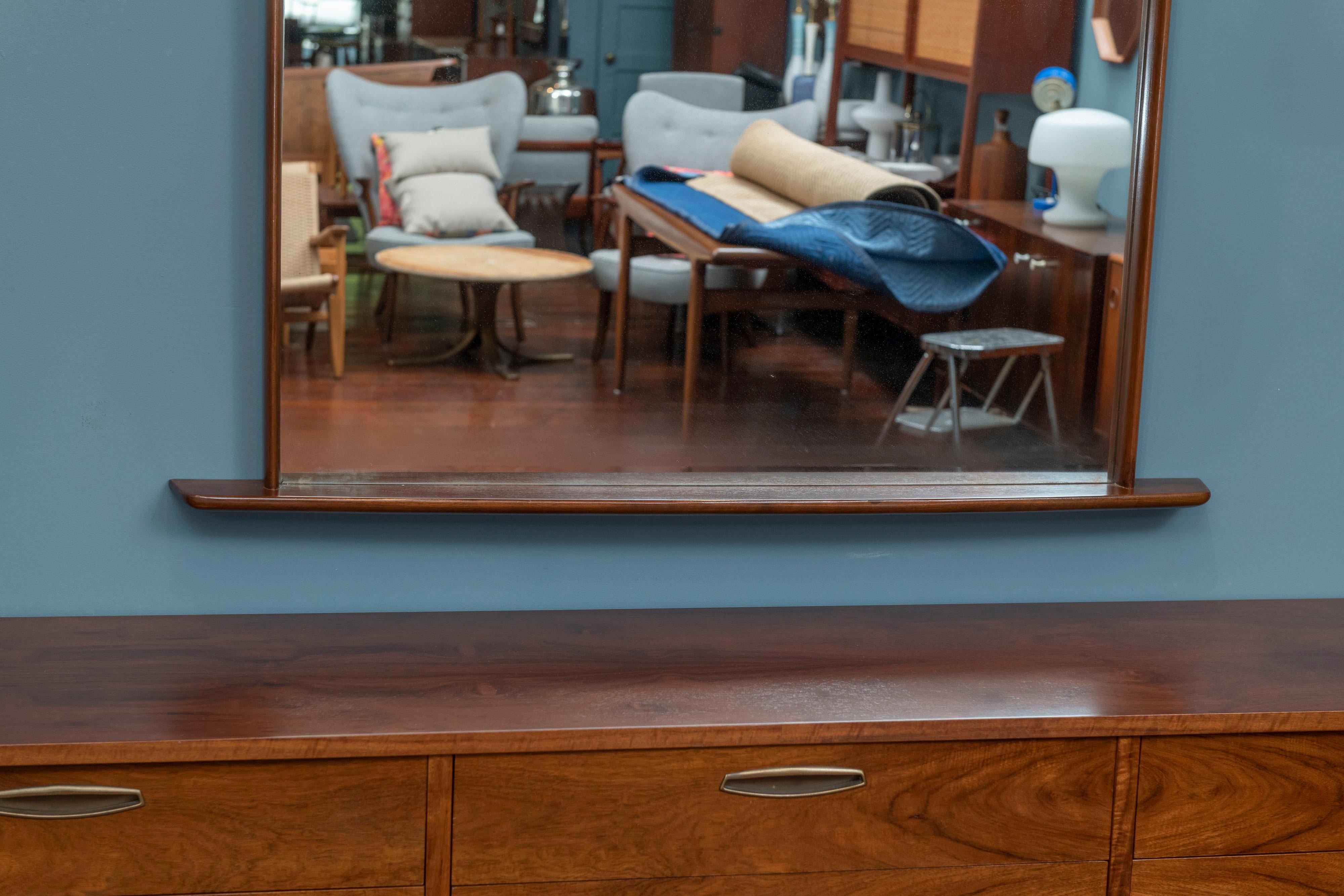 George Nakashima origins mirror. Stunning, substantial wall mirror constructed of solid walnut. Sculpted beams elegantly extend beyond the mirror’s frame. Has been lovingly used, and in excellent vintage condition. Wood is gleaming, and mirror has