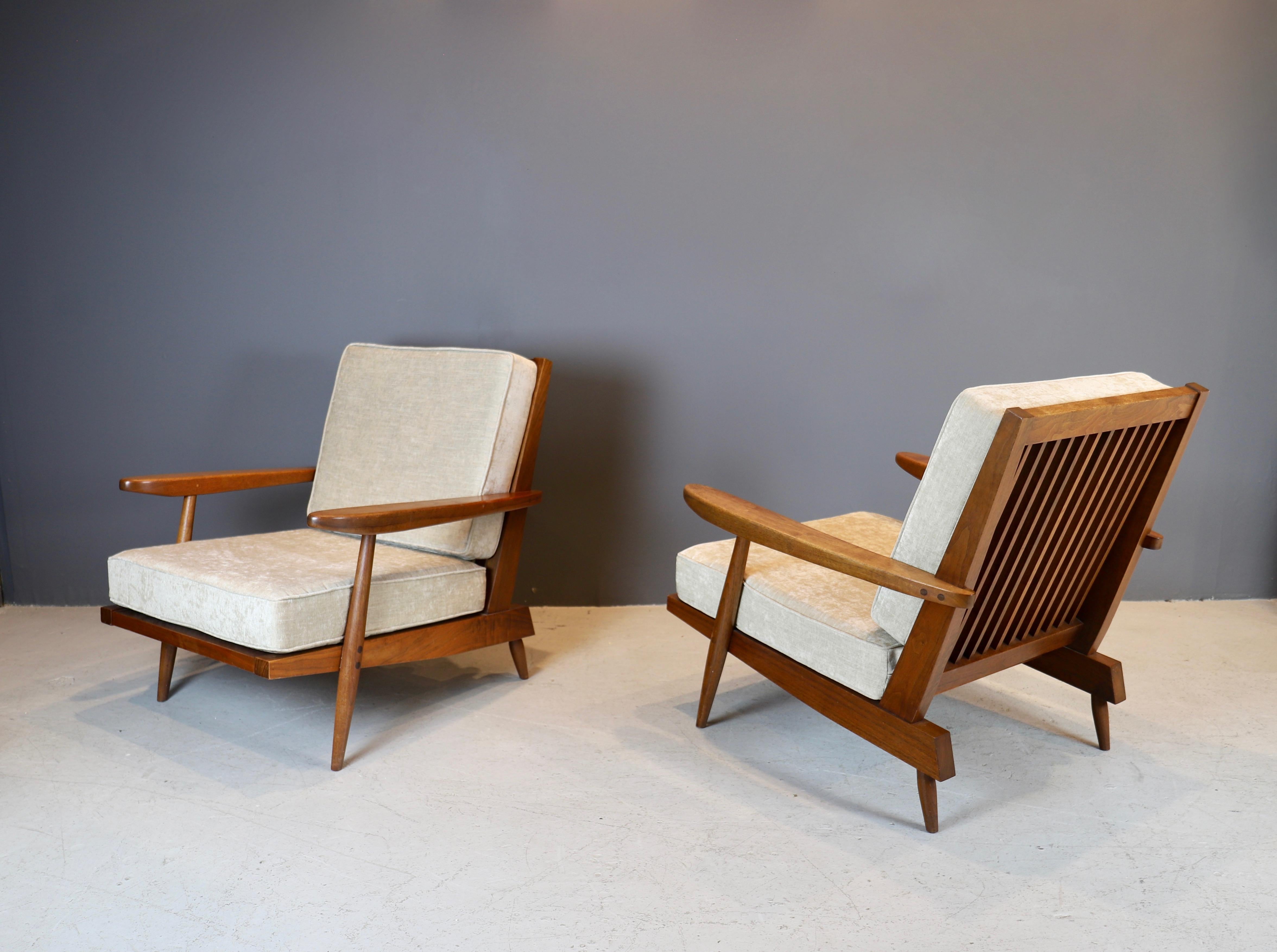 Iconic pair of lounge chairs by Japanese - American studio artist George Nakashima, produced in 1955. Chairs are in American walnut, showing Nakashima's masterful craftsmanship.
Cushions have been newly upholstered in Holly Hunt light sage