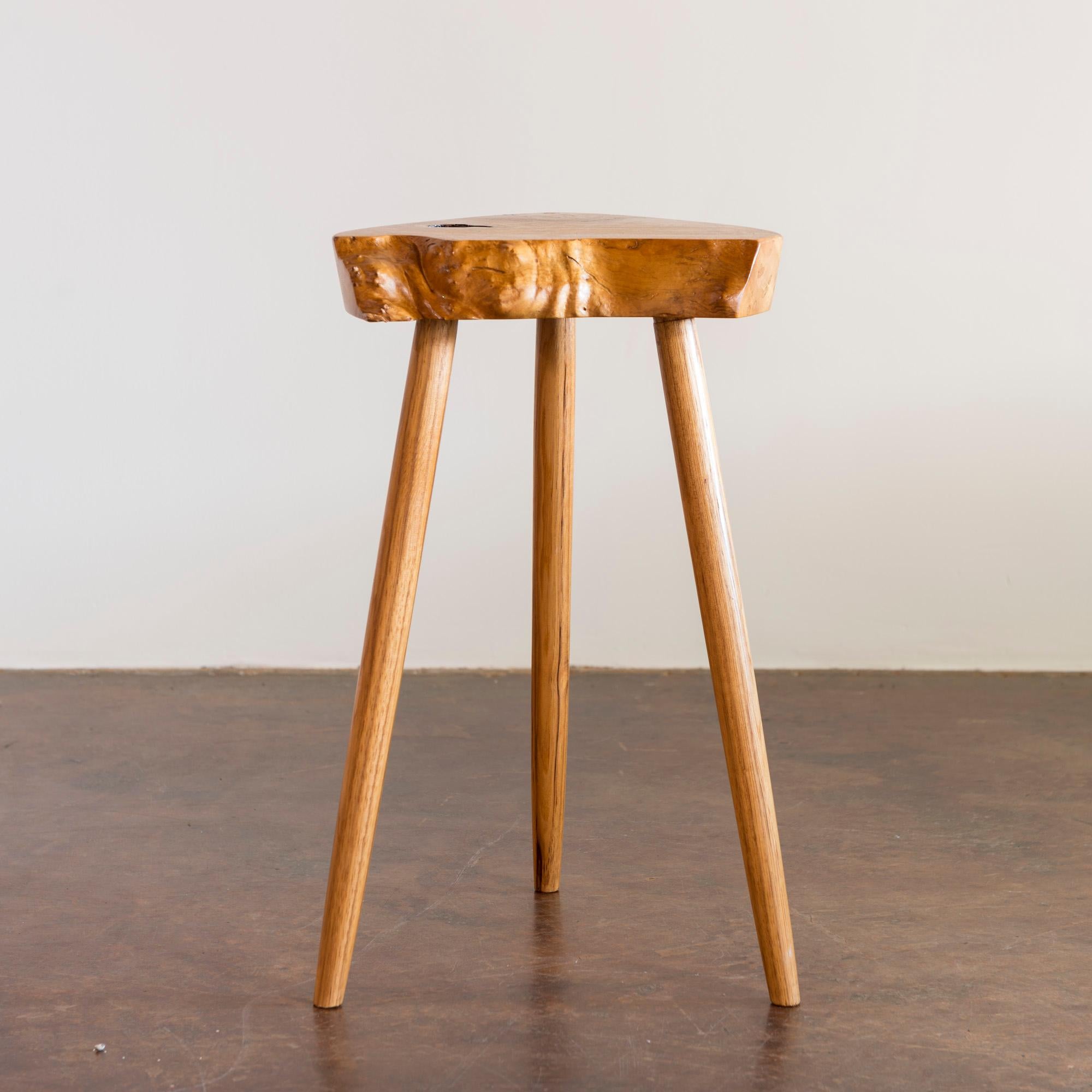 Petite, exceptionally proportioned early side table in ash featuring a triangular top with live edges and tapered legs.