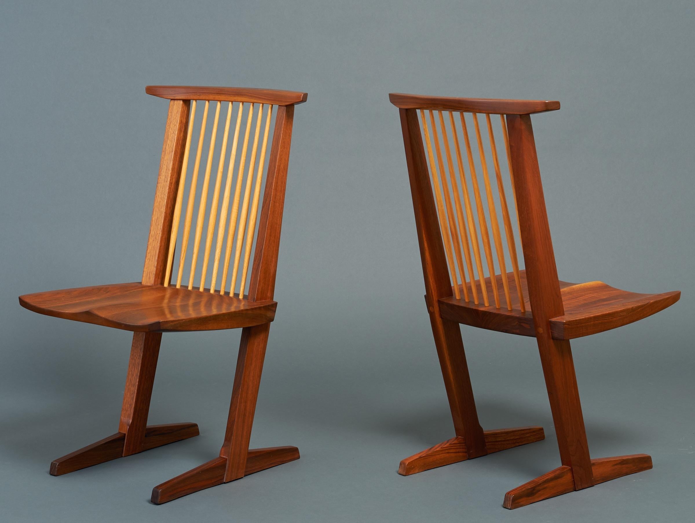 George Nakashima (1905–1990) 

An exceptional pair of Conoid chairs by Pennsylvania studio craft movement patriarch George Nakashima, among the last he sculpted before his death. In carved black walnut shot through with a tactile red and blond