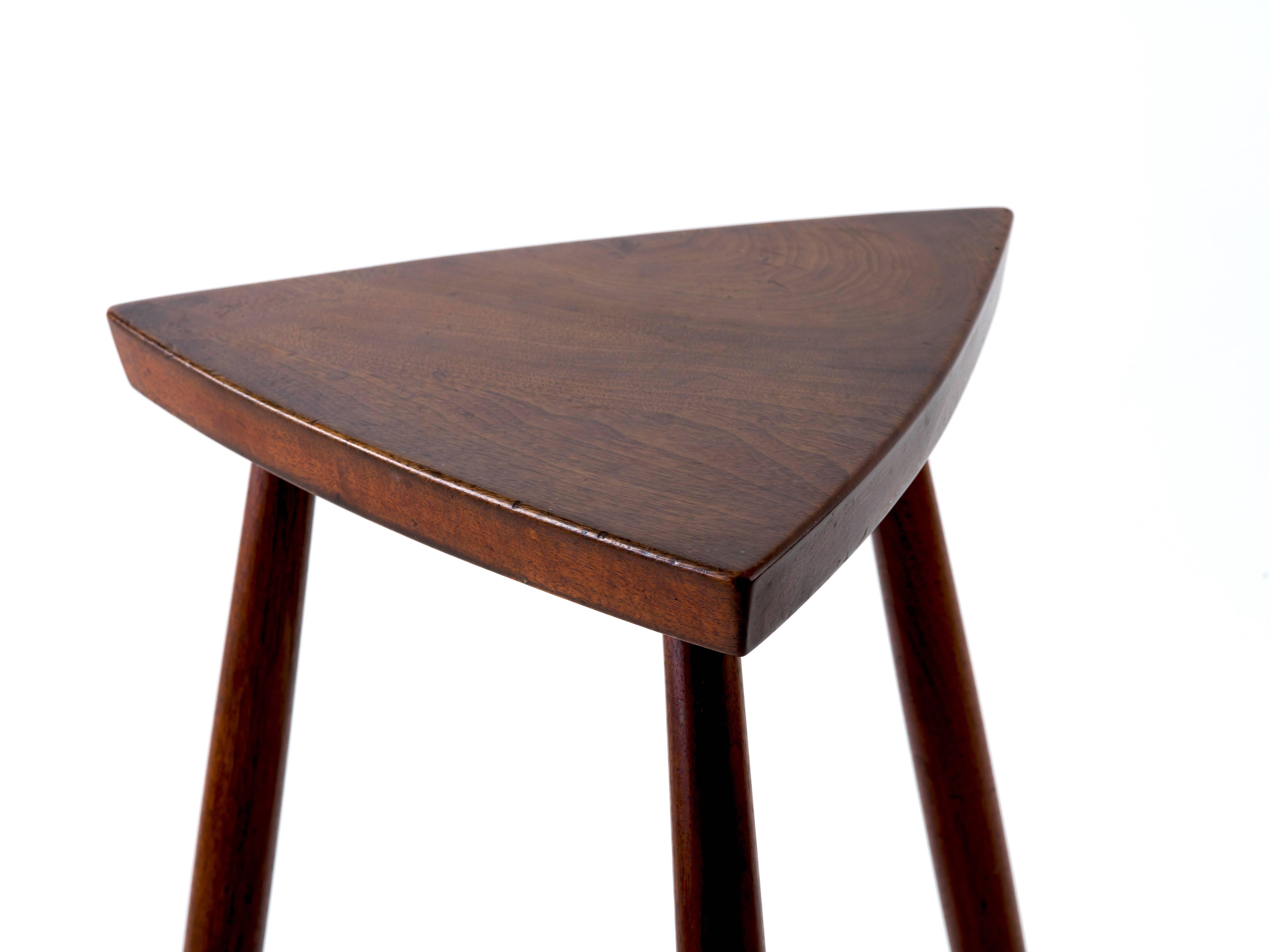George Nakashima counter-height stool in a scarcely-seen form for the master craftsman, executed in American black walnut and having a Reuleaux triangle-shaped seat. Rich patina to the original finish with original client’s surname handwritten to