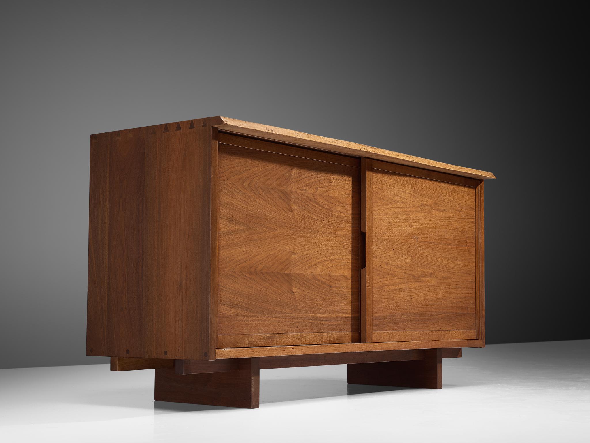 George Nakashima, sideboard, American walnut, New Hope, PA, 1959

Beautiful cabinet by George Nakashima with two sliding doors. The sideboard features the great details of Nakashimas craftsmanship like the wooden connections visible on top. Two