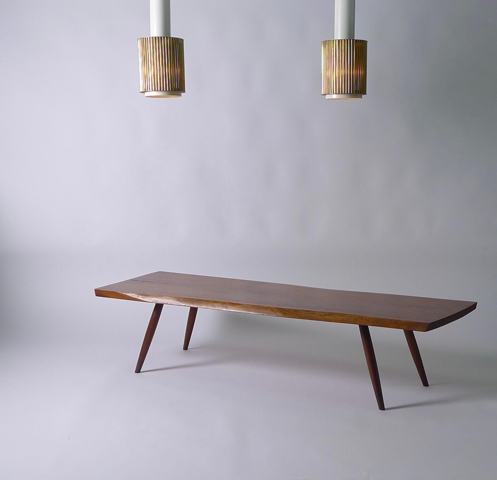 George Nakashima Studio, 1957, American Black Walnut coffee table constructed with a single slab top featuring a natural split to one end stabilised in typical Nakashima fashion with 2 Rosewood butterfly keys. Beutifully figured grain and sap