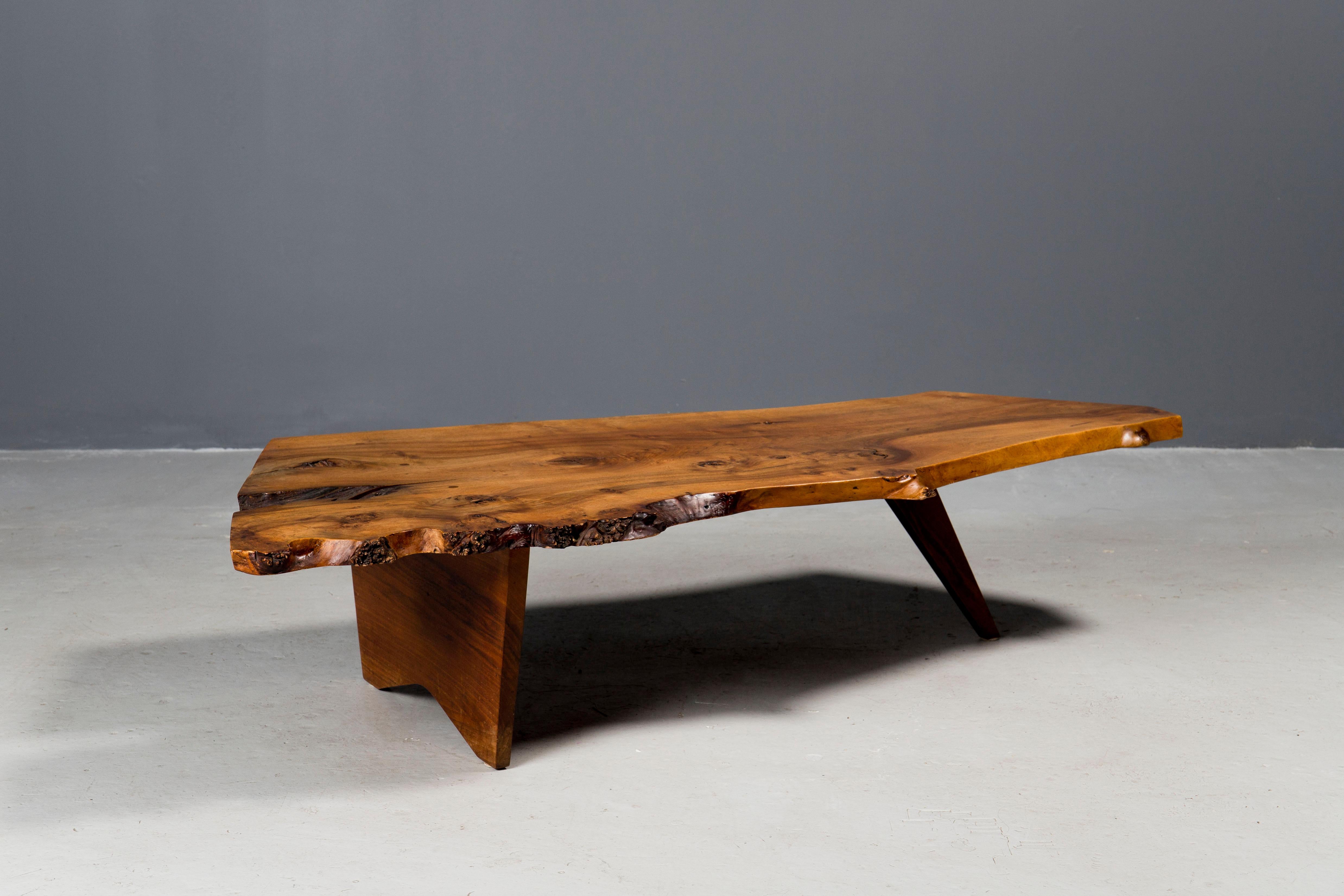 Early English and black American walnut coffee table by studio artist George Nakashima, ca 1950s, New Hope, PA.
Expressive burl live edge and highly figural grain throughout. 
Original condition and warm patina.
Documented and copy of the order