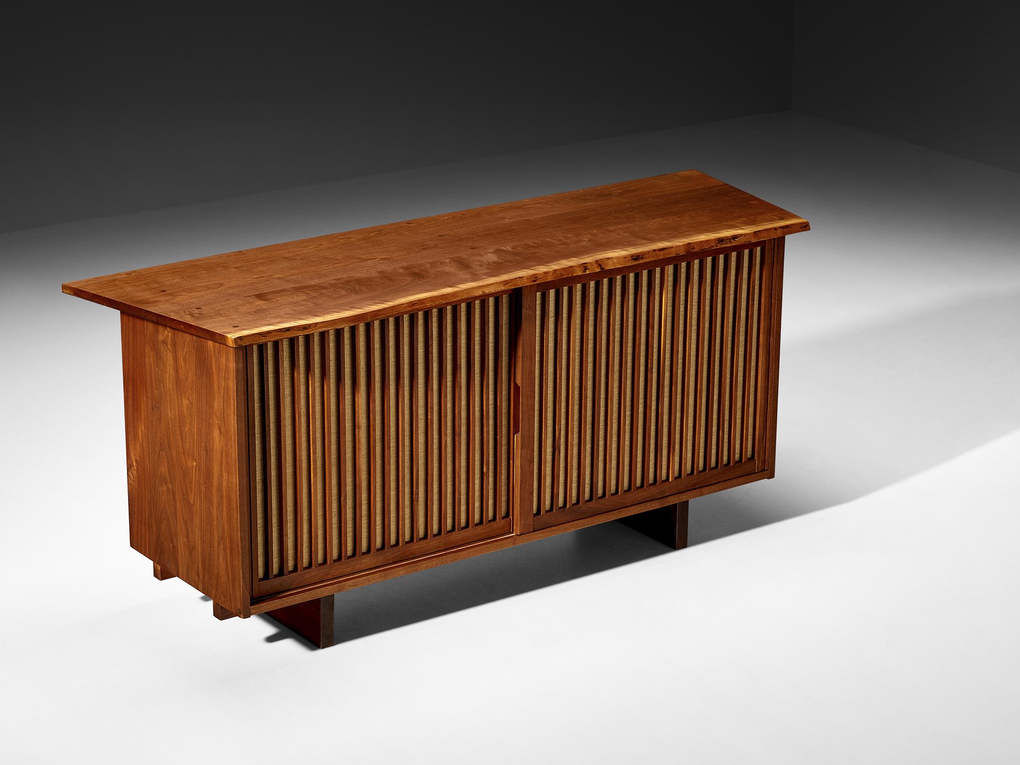 George Nakashima for Nakashima Studio, sideboard, walnut, pandanus cloth, United States, 1966. 

With regard to its essential form, material use, and woodwork, this two-door sliding-door sideboard is a testimony to George Nakashima's expert