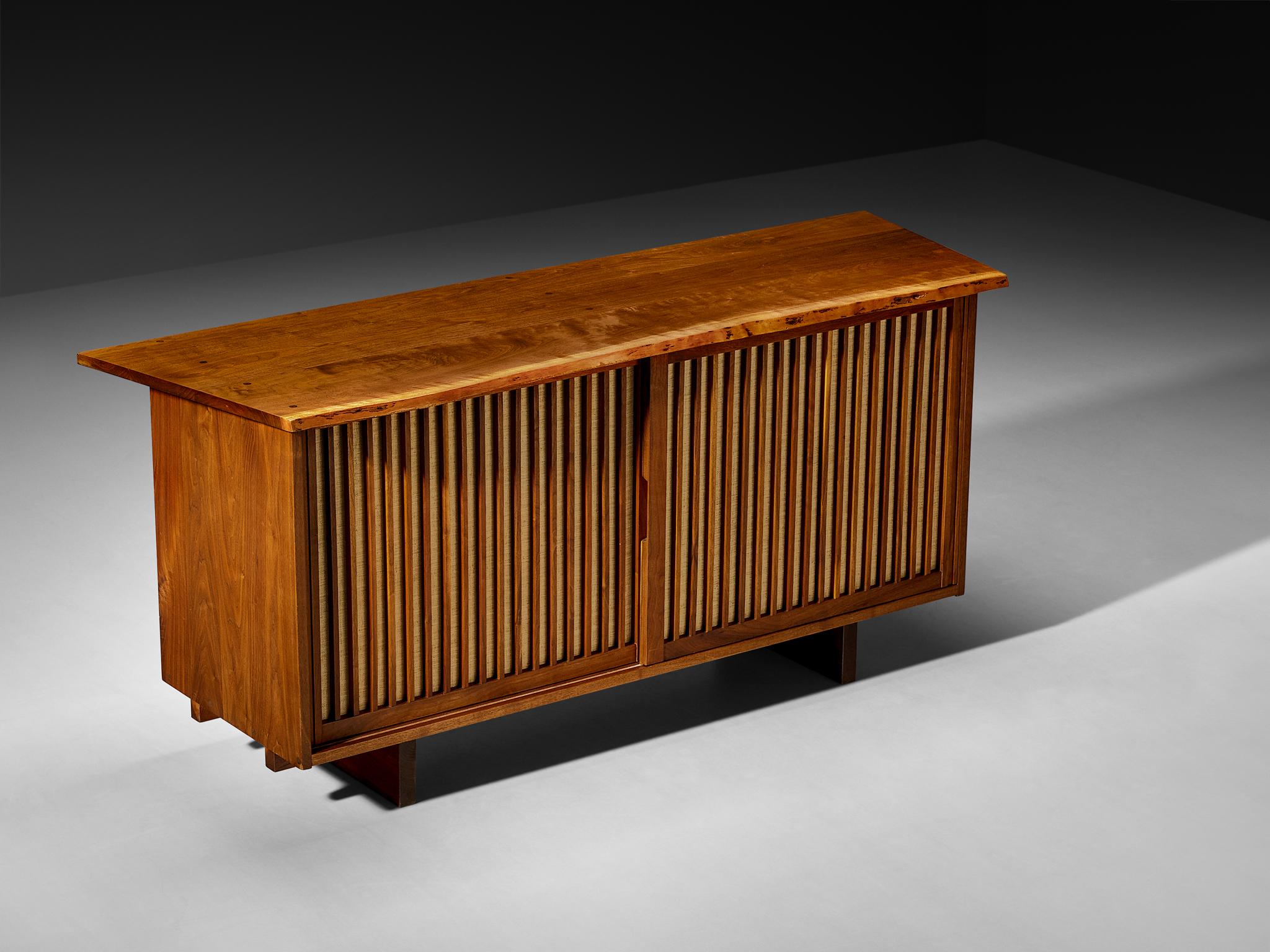 George Nakashima for Nakashima Studio, sideboard, walnut, pandanus cloth, United States, 1966. 

With regard to its essential form, material use, and woodwork, this two-door sliding-door sideboard is a testimony to George Nakashima's expert