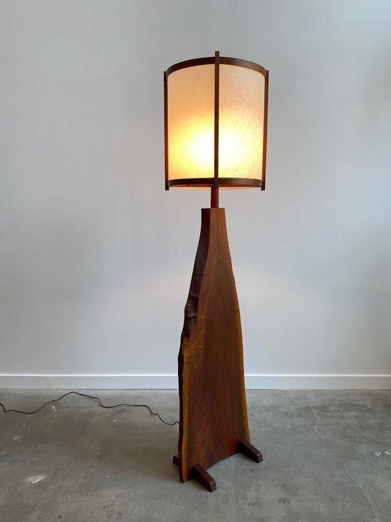 Wooden slab floor lamp. The body of this lamps features a beautifully crafted Live edge wooden slab supported by two smaller slabs of the same American walnut wood. The shade is expertly made and is sturdy sitting on the socket base.