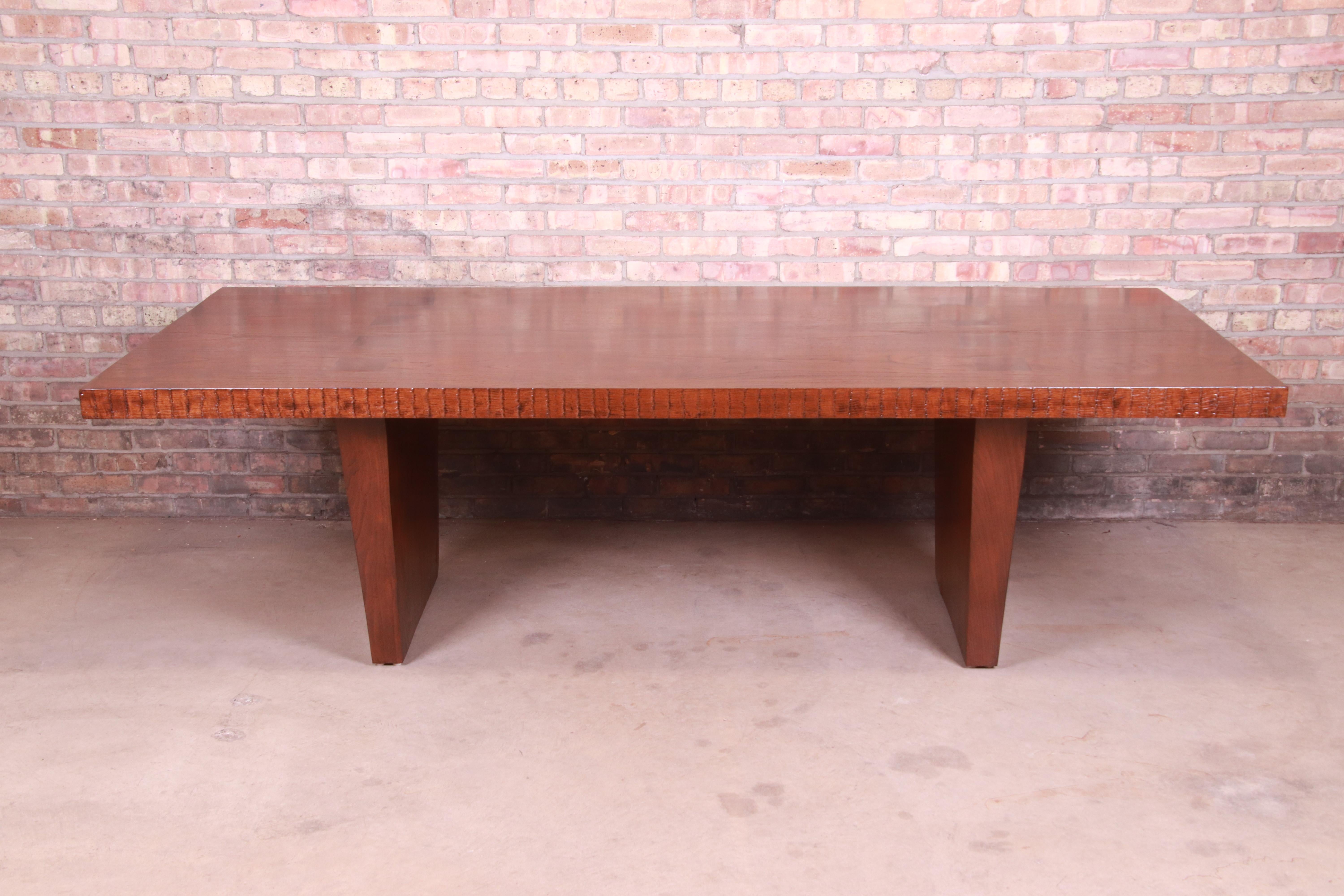 An exceptional organic modern studio craft dining table or executive writing desk

In the manner of George Nakashima

USA, 20th century

Thick solid walnut slabs, with exposed mortise and tenon joints. One side with textured live