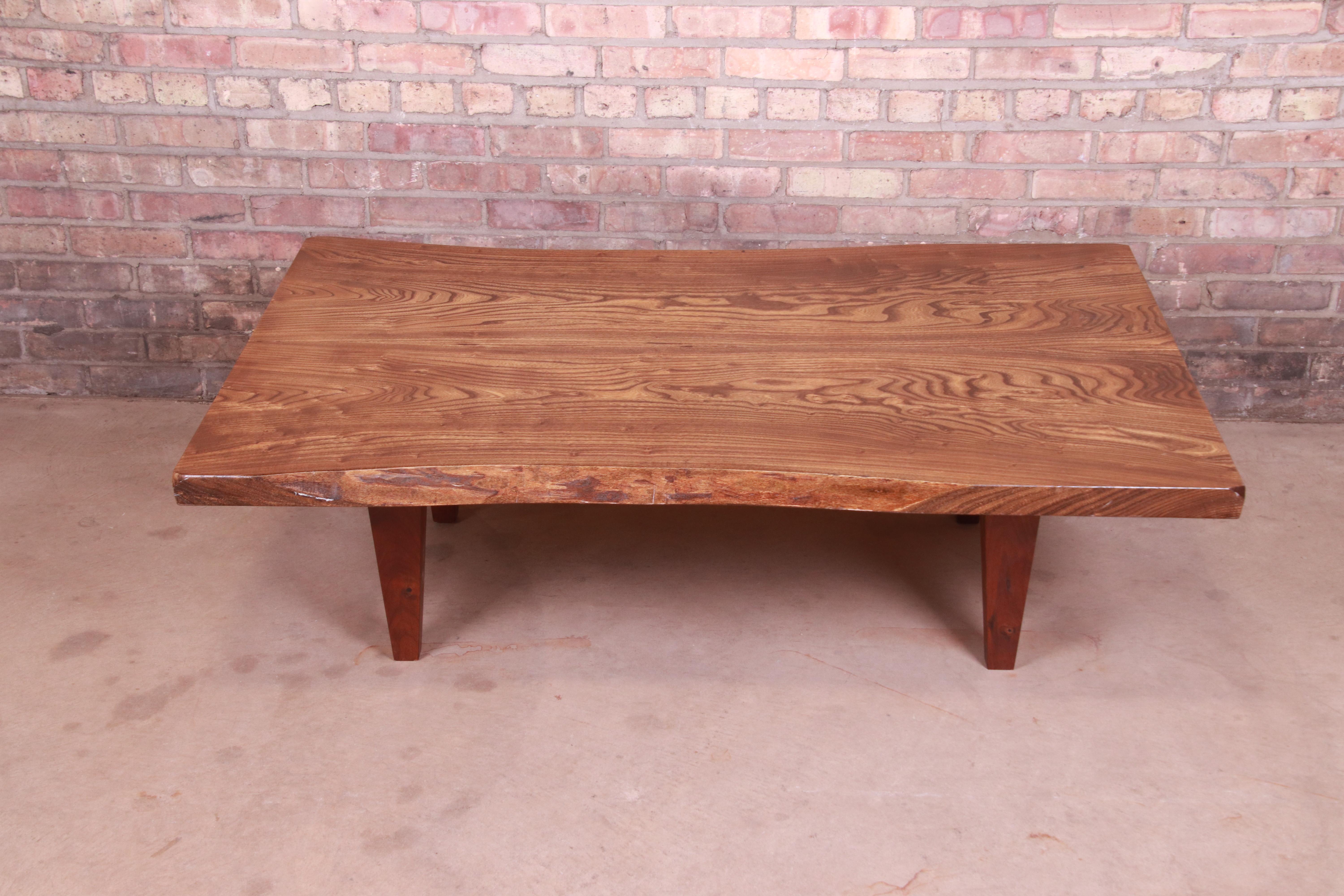 An exceptional studio crafted organic modern coffee or cocktail table

In the manner of George Nakashima

By Terrence Karpowicz (signed and dated by artist)

USA, 2008

Solid walnut free form live edge table top, with tapered solid walnut
