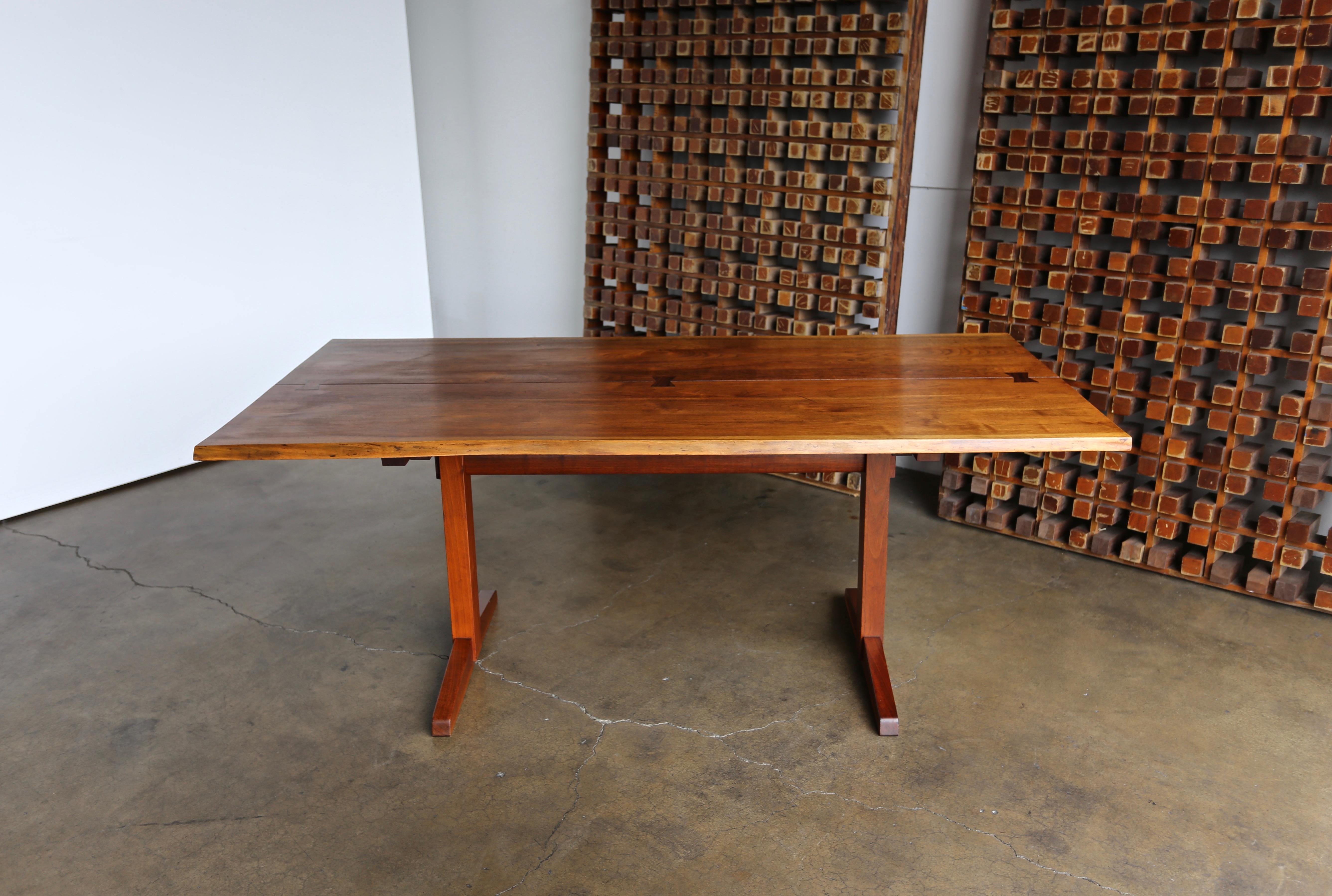George Nakashima trestle dining table, 1960. Table consists of two solid boards joined by three rosewood butterflies. Signed with client's name to underside.