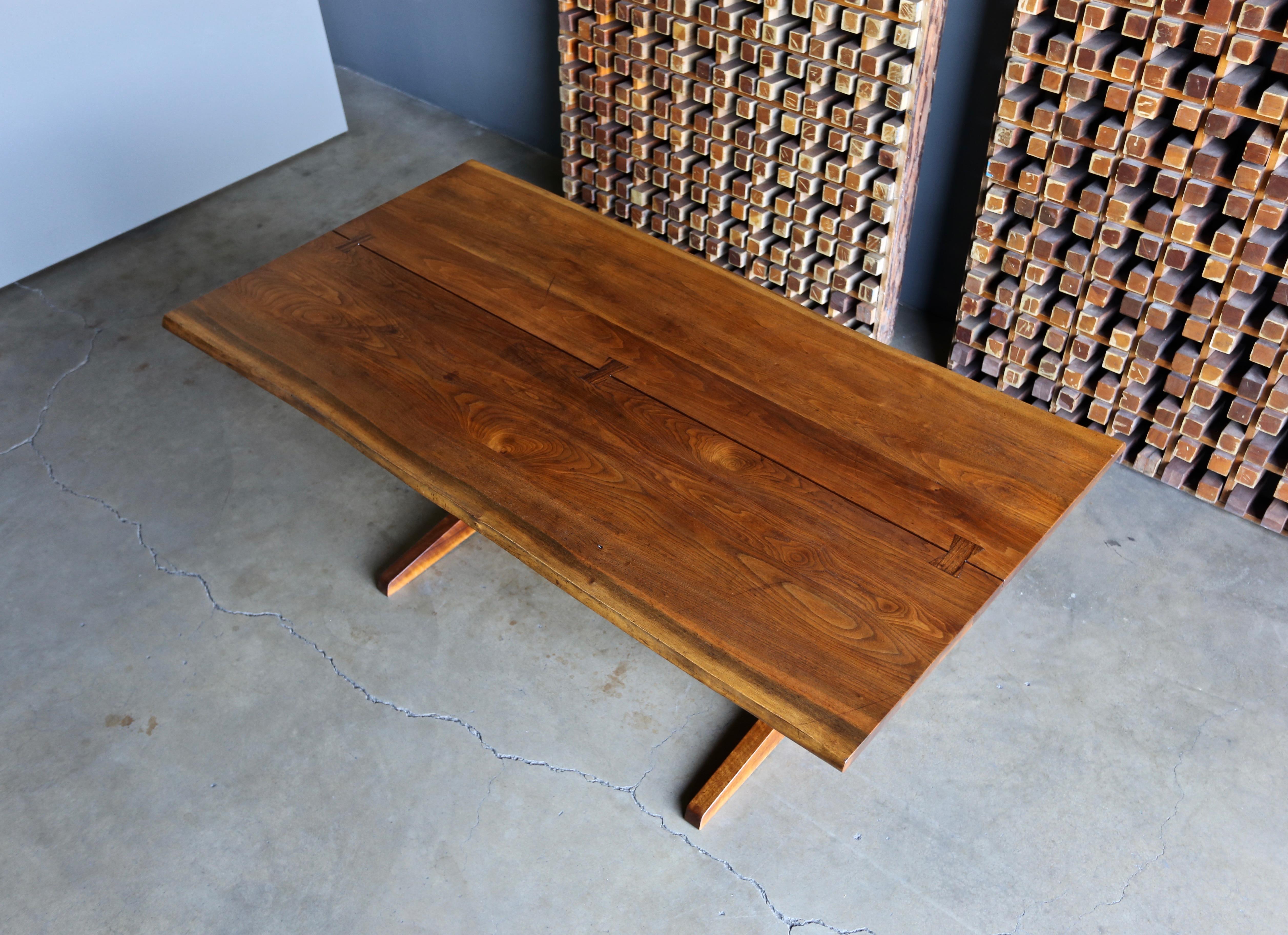 George Nakashima trestle dining table, 1960. Table consists of two solid boards joined by three rosewood butterflies. Signed with client's name to underside. This piece also functions nicely as a writing table. This piece is in original condition.