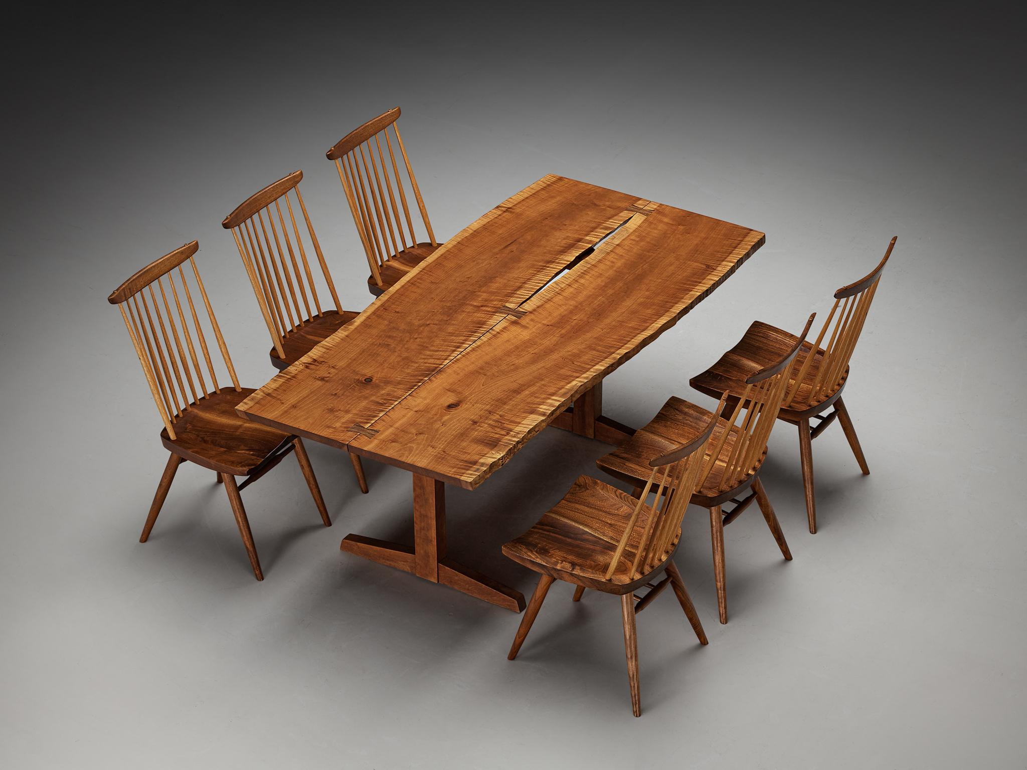 George Nakashima dining room set consisting of a 'Trestle' dining table with 'New' dining chairs 


George Nakashima for George Nakashima Studio, boat-shaped ‘trestle’ dining table, cherry, rosewood, United States, 1982

This exquisite dining table