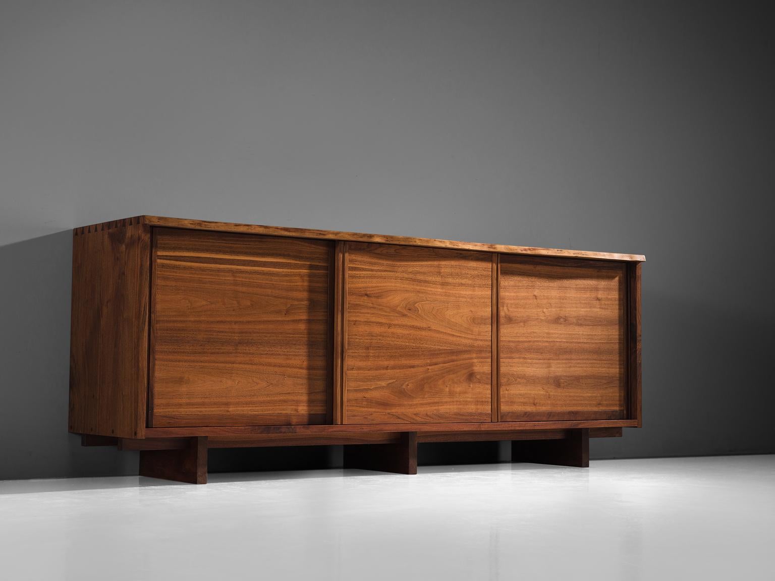 George Nakashima triple sliding door cabinet, made in walnut, United States, 1963. 

Cabinet with three sliding doors and four drawers behind each door, executed in walnut with traditional and archetypical dovetail Nakashima wood-joints. The top of