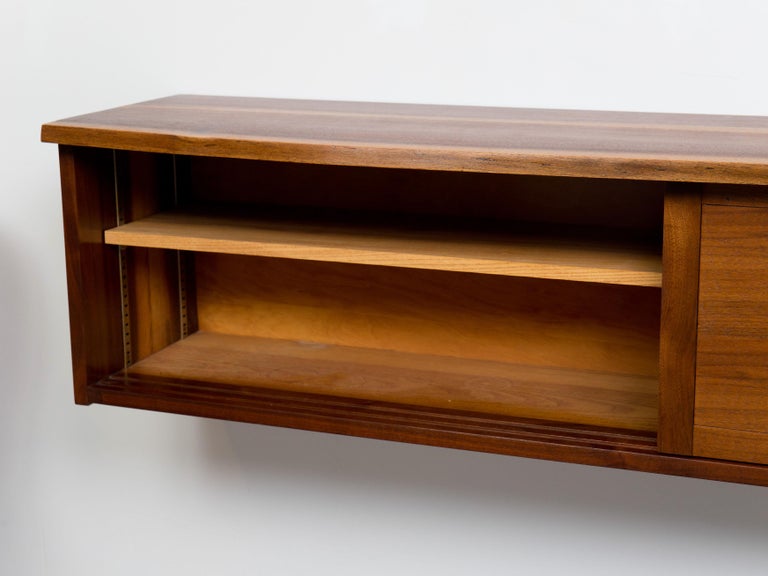 Wall-hung, a symmetric cabinet by studio artist George Nakashima, New Hope, PA, ca 1960s
This piece features a live walnut edge top with beautiful figuration and two door concealed storage.
This cabinet has been cleaned and properly treated with