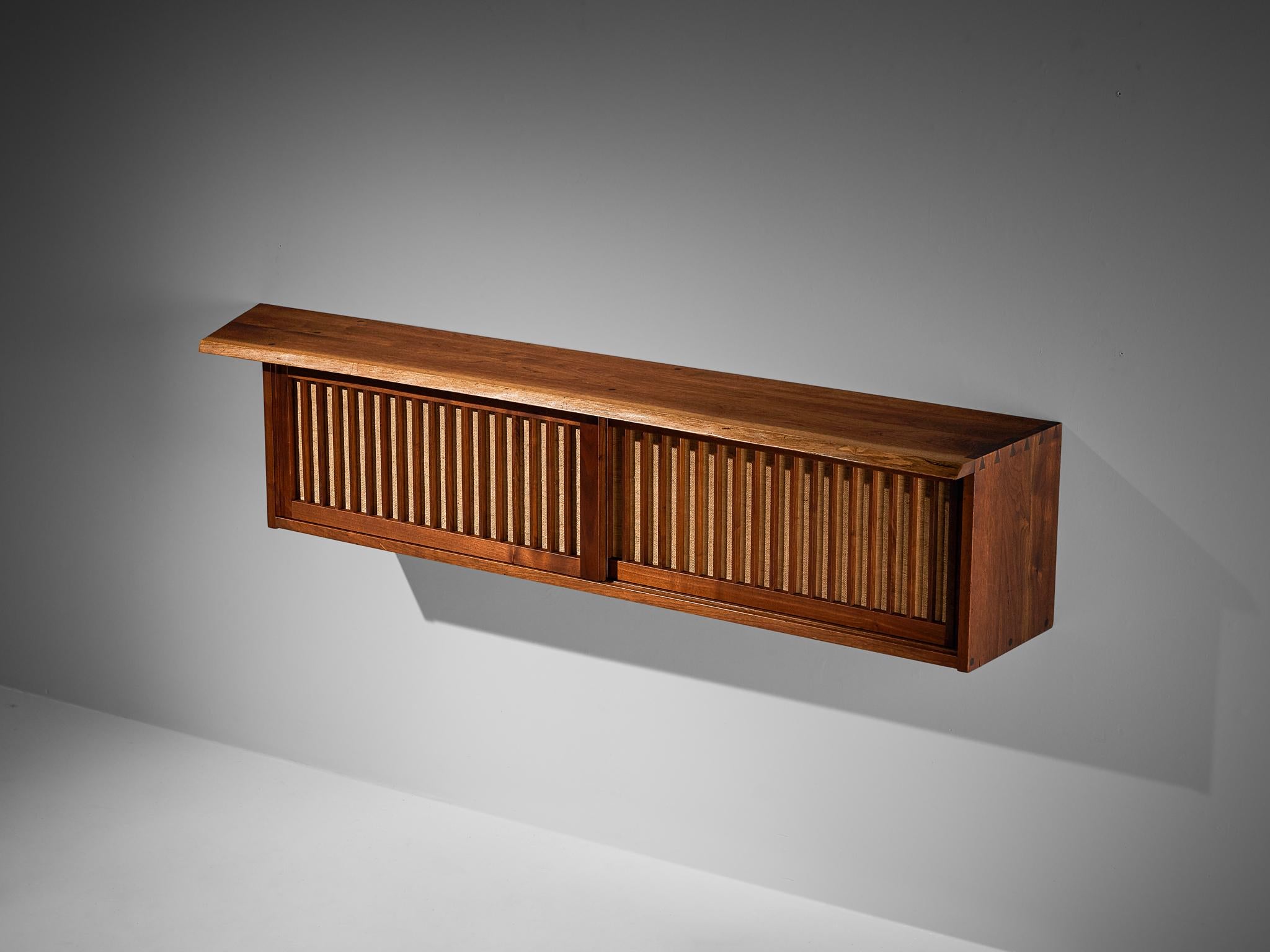 George Nakashima, sliding-door wall-mounted cabinet, American black walnut, pandanus cloth, United States, 1963

With regard to its essential form, material use, and woodwork, this sliding-door wall-mounted cabinet is a testimony to George