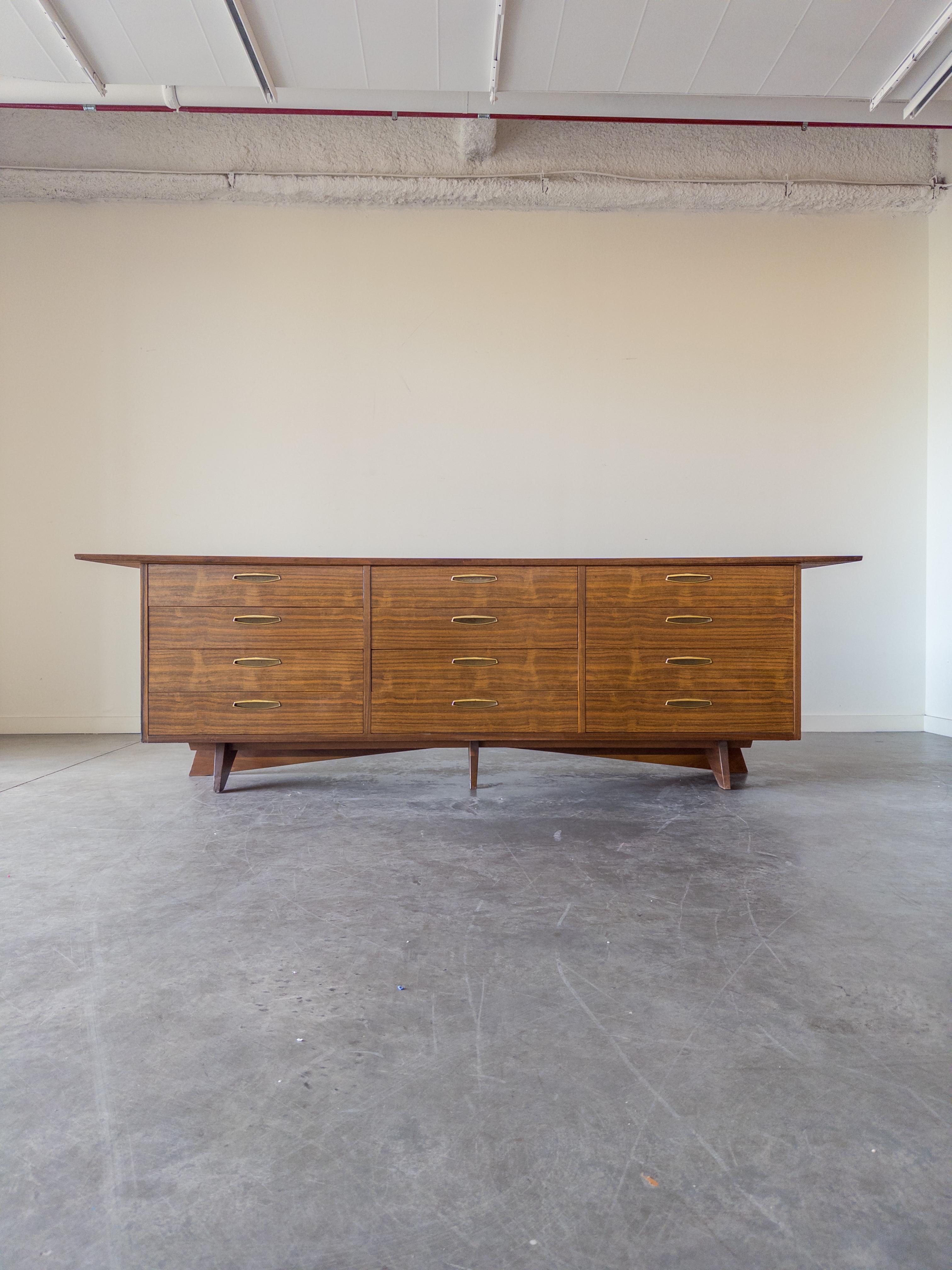 Un rarissimo comò, credenza o credenza tripla monumentale di George Nakashima per Widdicomb Furniture, Collection'S, 1950. Realizzato in noce scolpito, con ferramenta originale in ottone.
Il mobile è dotato di dodici cassetti. Firmato con marchio