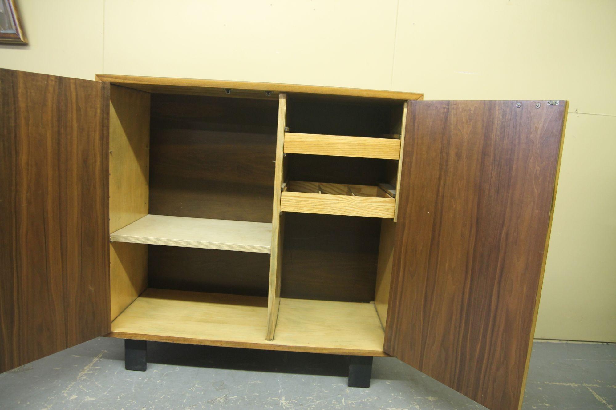 Rarely seen 2 door cabinet by George Nelson. Inside cabinet has two sliding draws on right side and a single replacement shelf on left side. There is room for more shelve if desired. Piece retains its original laminate top.