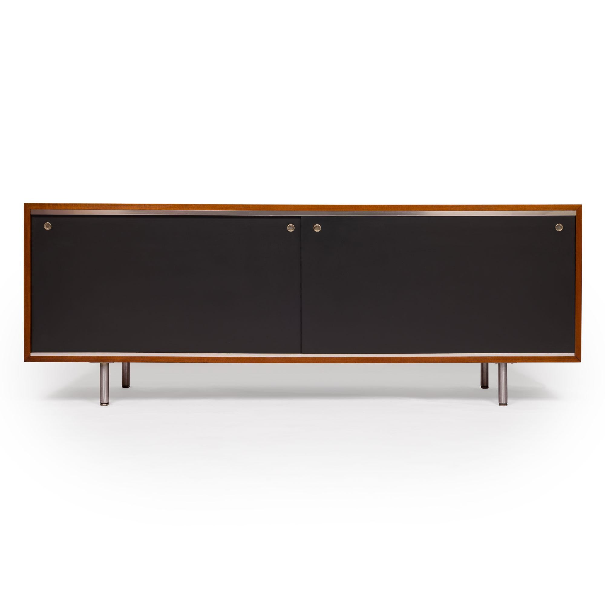 Este excepcional aparador con exterior de nogal y puerta negra fue diseñado por George Nelson para el Executive Office Group de Herman Miller hacia 1962. Este magnífico diseño moderno de mediados de siglo es muy llamativo y ofrece mucho espacio de
