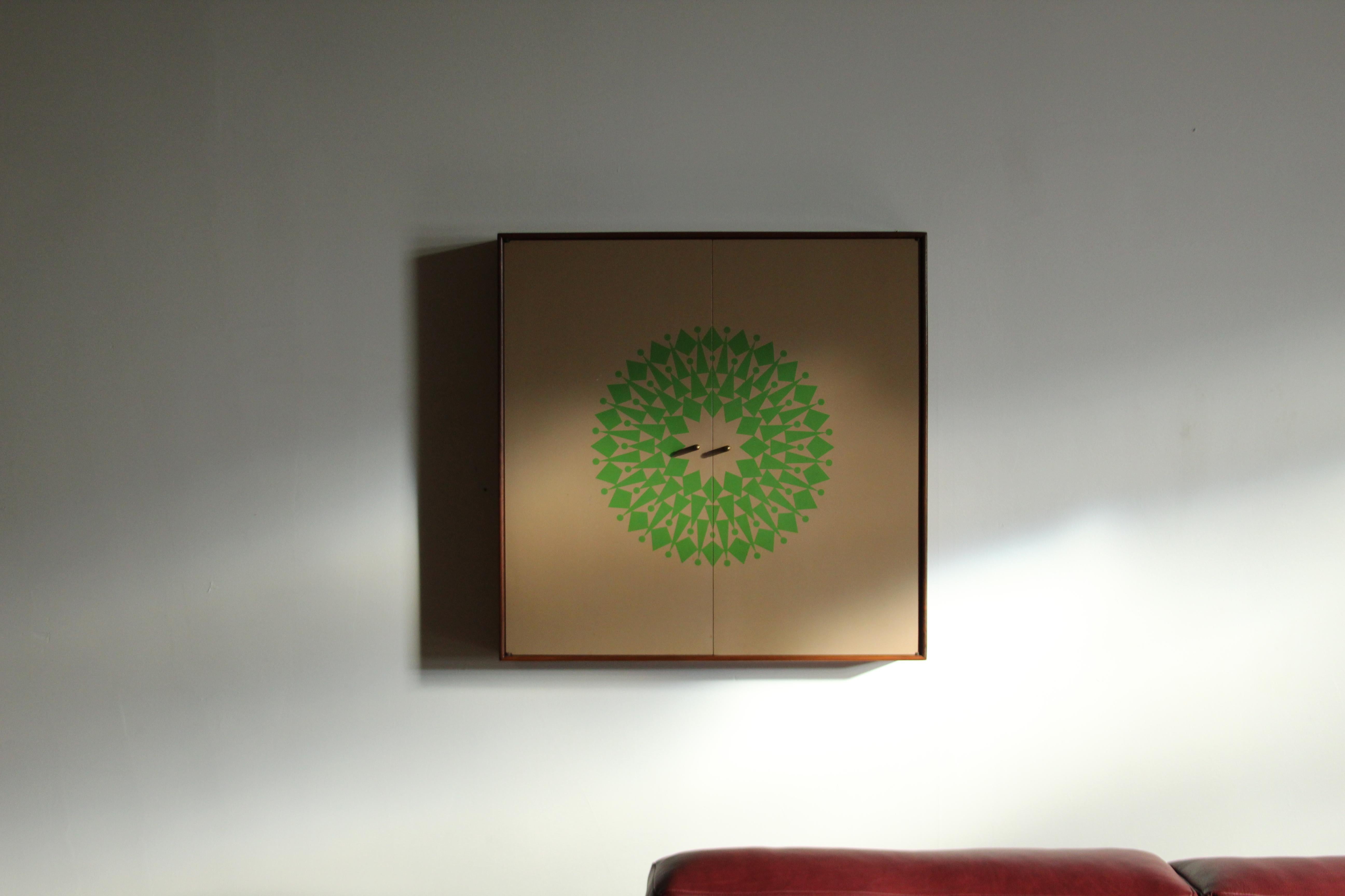Un armadio a muro estremamente raro, progettato in collaborazione da George Nelson e Alexander Girard nel 1964 come parte della linea di accessori di Herman Miller. Il mobile è dotato di due ante che si aprono su quattro ripiani poco profondi e di