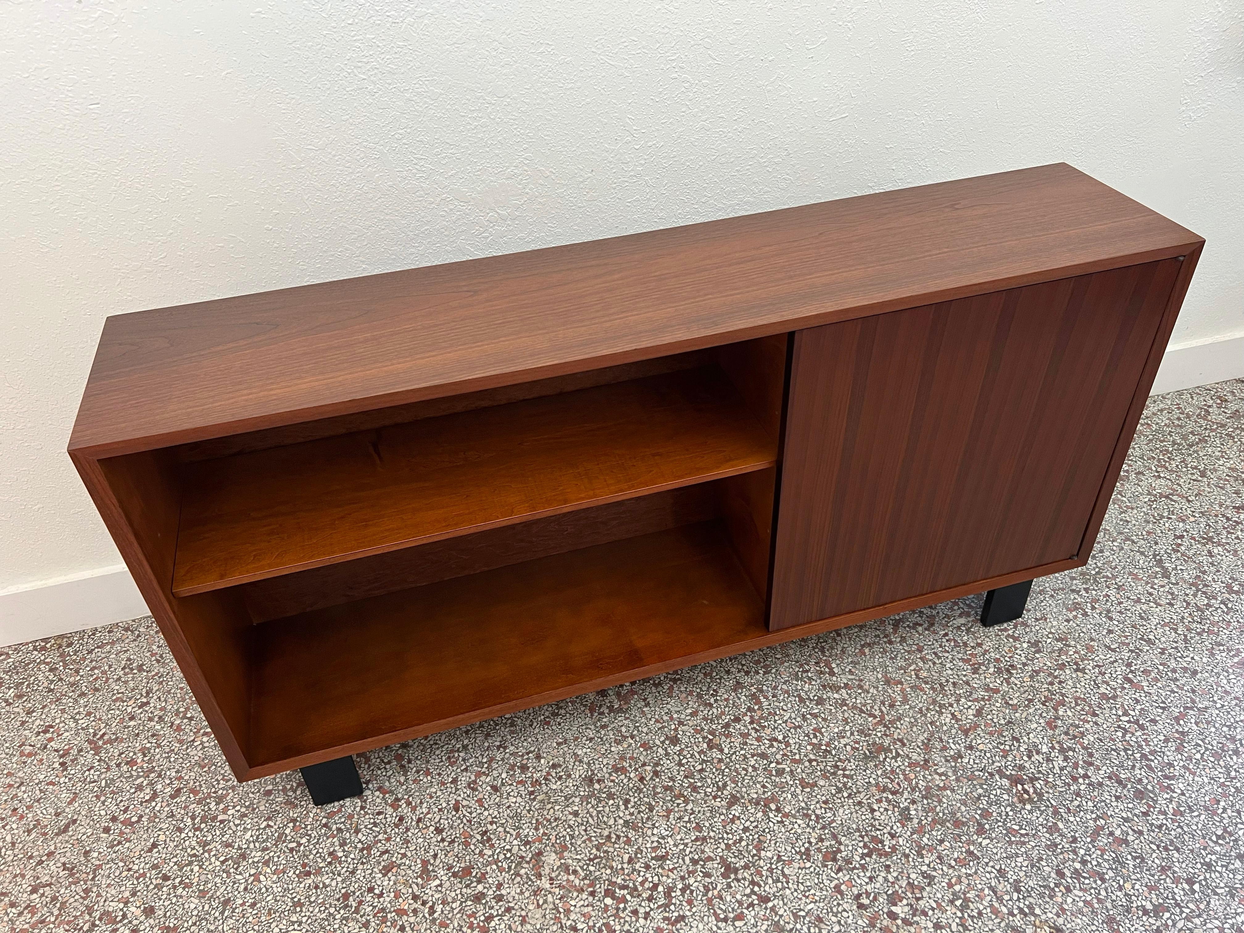 Vintage open shelf cabinet designed by George Nelson for Herman Miller as part of the BCS (Basic Cabinet Series). Crafted in beautiful walnut with adjustable shelving and a single hinged door. 

Designer: George Nelson

Manufacturer: Herman