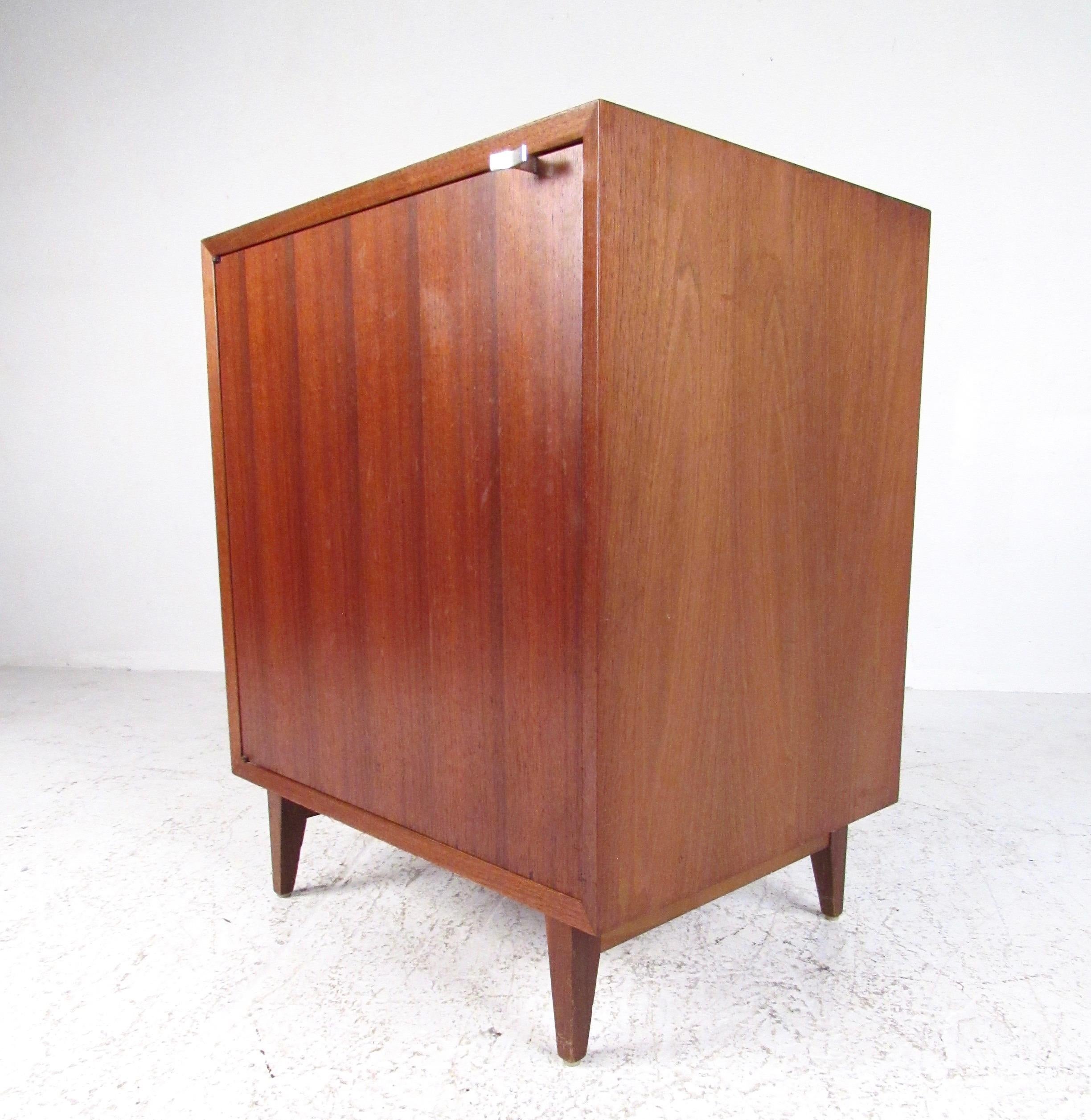 This striking Mid-Century Modern cabinet features the quality vintage design of George Nelson for Herman Miller. Rich walnut wood tone and iconic George Nelson designed chrome handle add to the simple yet elegant mid-century appeal of the piece.