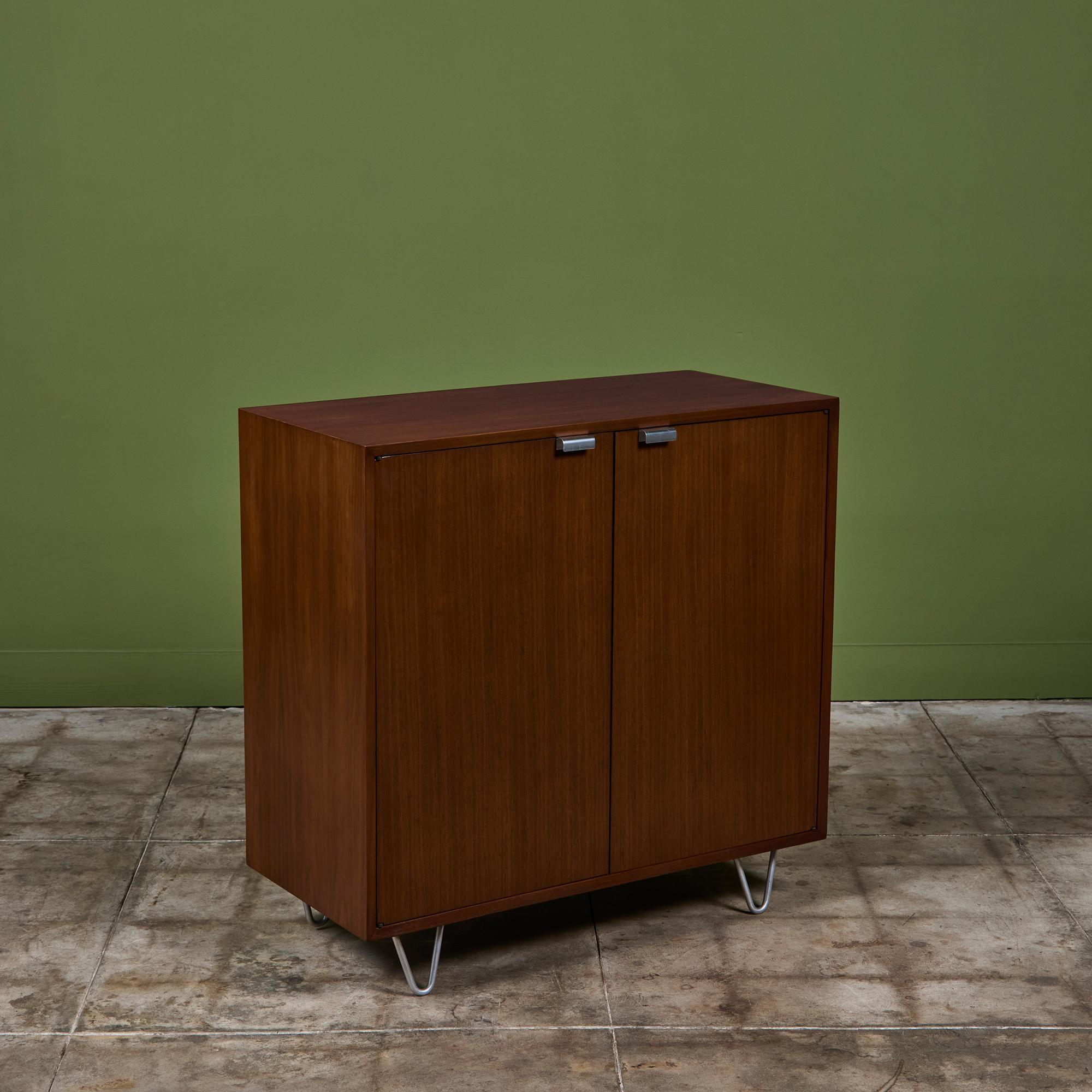 Armadio BSC di George Nelson per Herman Miller, anni '50 circa, USA. Il design è caratterizzato da un mobile a due ante in noce con ripiani interni. Ogni anta dell'armadio è dotata di un tiretto in alluminio lucido. La cassa poggia su quattro gambe