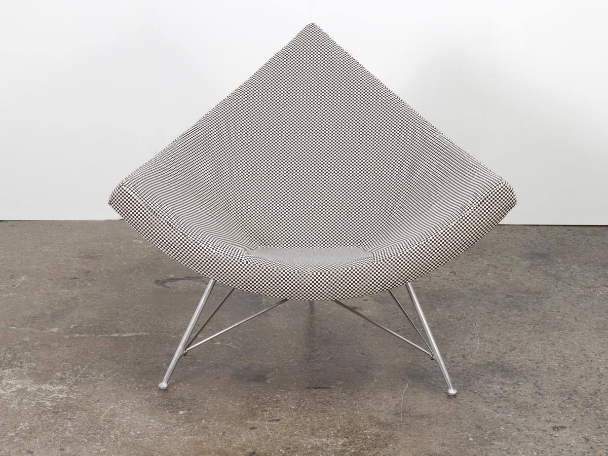 Iconic coconut chair designed by George Nelson. A low-slung lounge profile with spacious seat for superior comfort. Triangular fiberglass shell rests on architectural brushed-steel tripod base with nice patina throughout. Our early vintage example