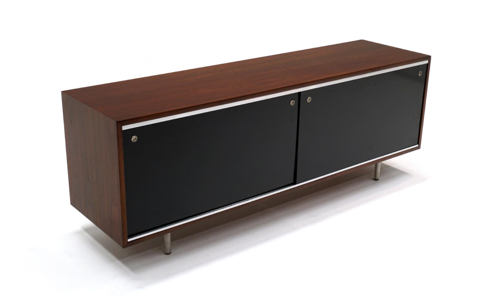 George Nelson for Herman Miller credenza / storage / media cabinet. This is an iconic midcentury design. Walnut case with sliding black panel doors revealing drawers and adjustable shelves. Expertly restored and refinished. Function perfectly. In