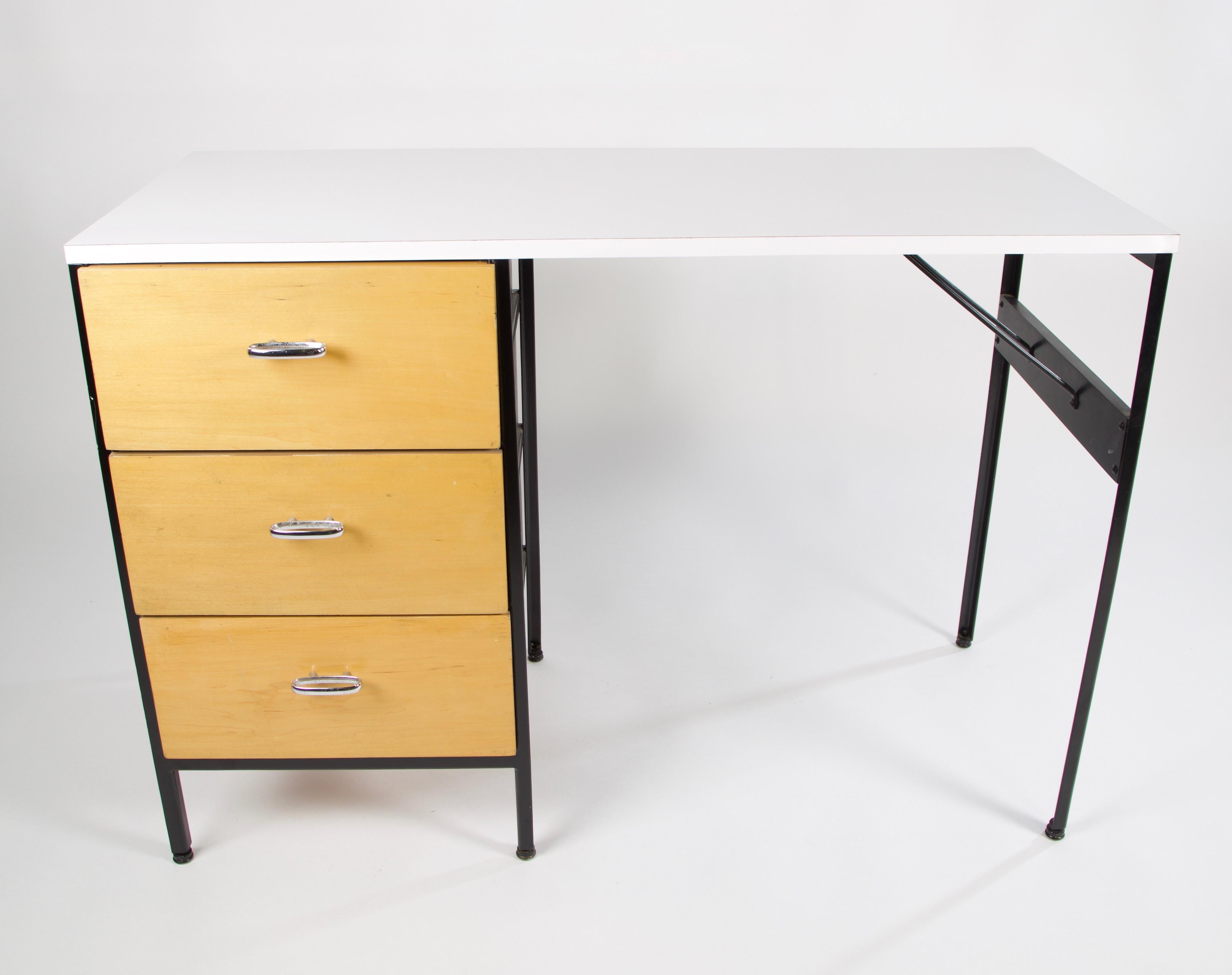 A vintage model 4111 desk from the Steel frame series of furniture by George Nelson & Associates for Herman Miller. This architectural minimalist desk has been restored including a new white formica top. It has 3 drawers with light stained fronts