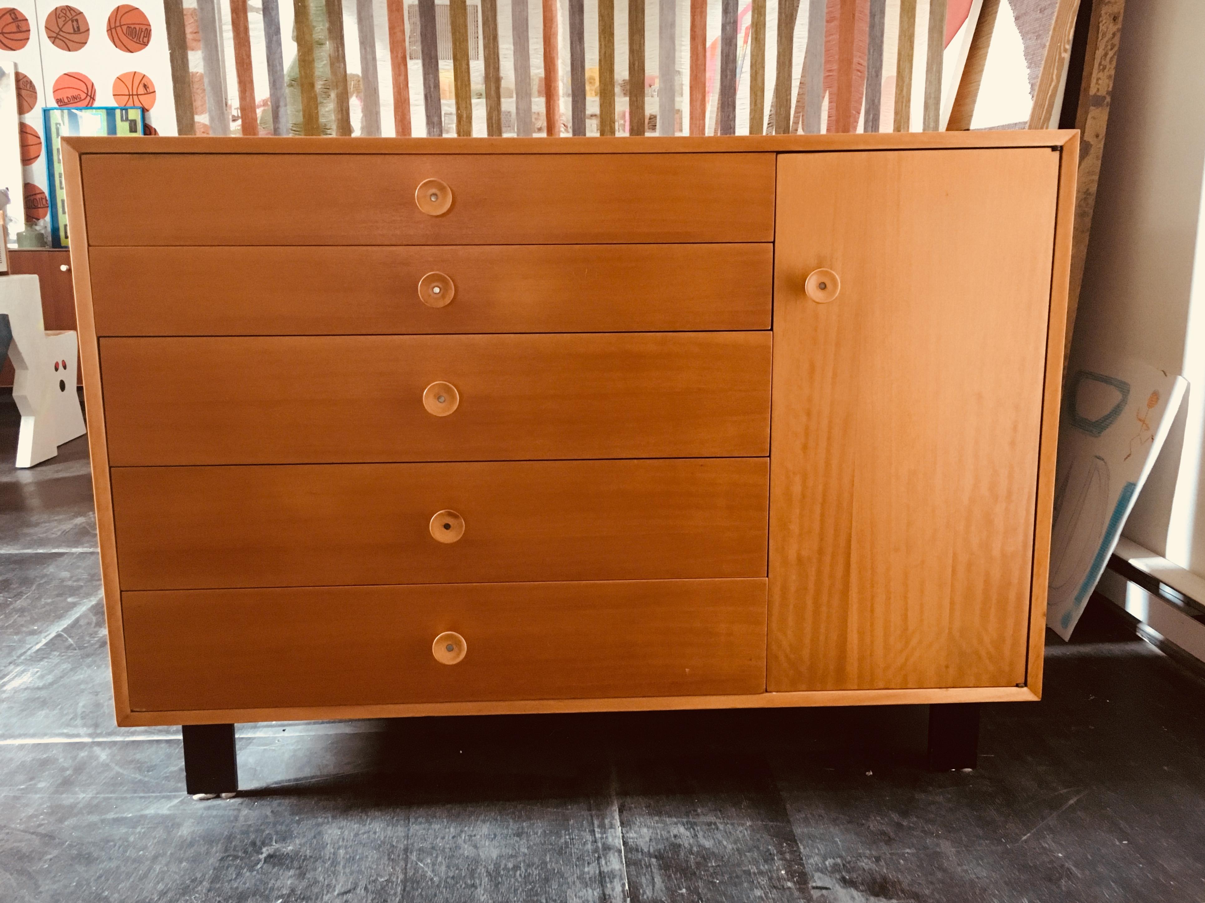 Five-drawer Birch dresser with side cabinet containing two adjustable shelves, designed by George Nelson for Herman Miller, ca 1950. 
Identifying label in the upper drawer, excellent vintage condition.