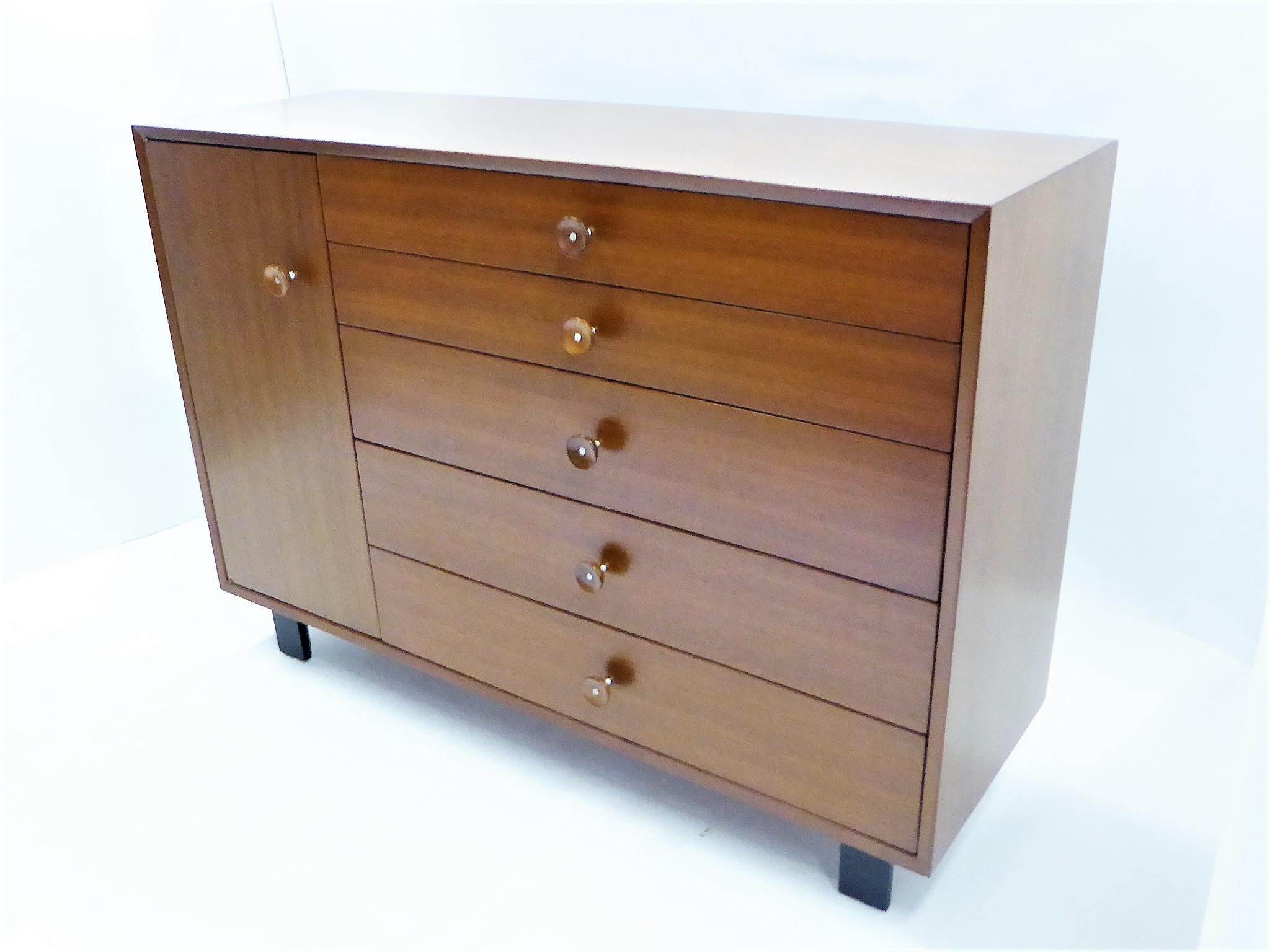 .George Nelson designed this walnut cabinet, dresser or credenza for Herman Miller as part of their basic cabinet series, Mid-Century Modern Classics. This one sometimes referred to as model 4935. The case sits on black shaped block feet. To the