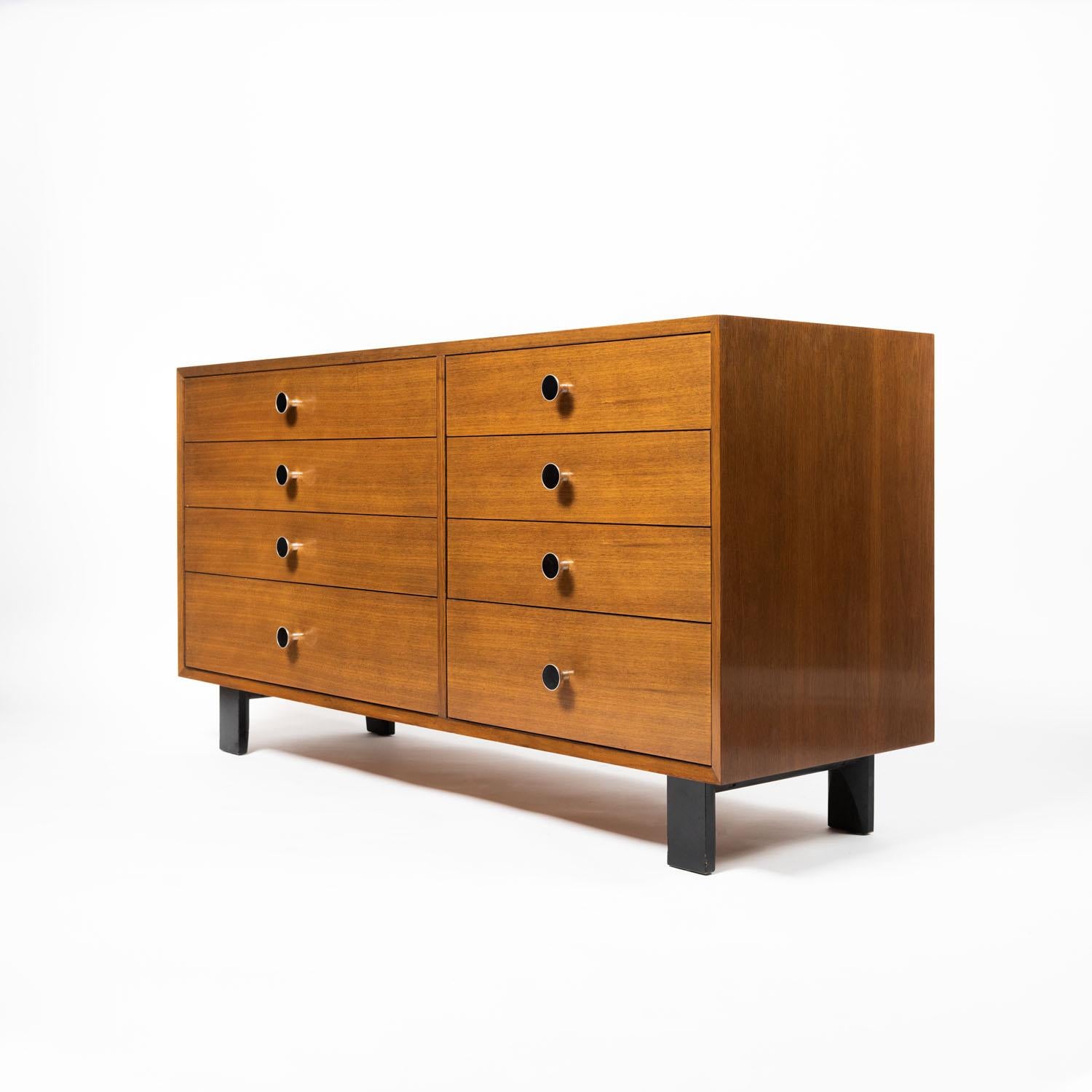 A George Nelson eight drawer dresser for Herman Miller in walnut with rare round pull handles in original black lacquer inlay, circa 1960s. Original George Nelson for Herman Miller label intact inside drawer and original finish. George Nelson was an
