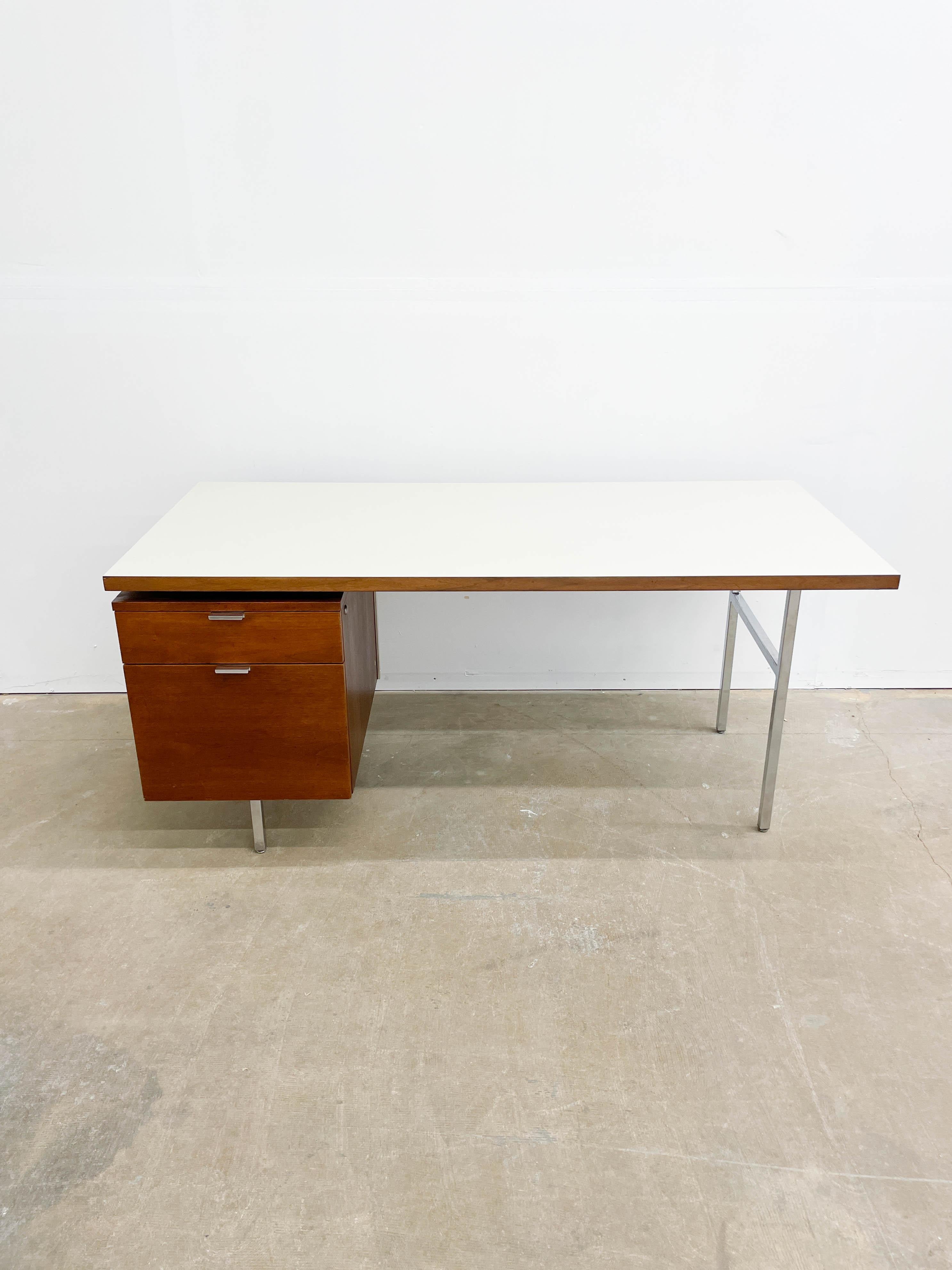 This is a Classic Mid-Century Modern desk in Walnut and white Formica that was designed by George Nelson for Herman Miller's Executive Office Group (better known today as EOG) in the 1950s. Clean lines and functionality are the name of the game