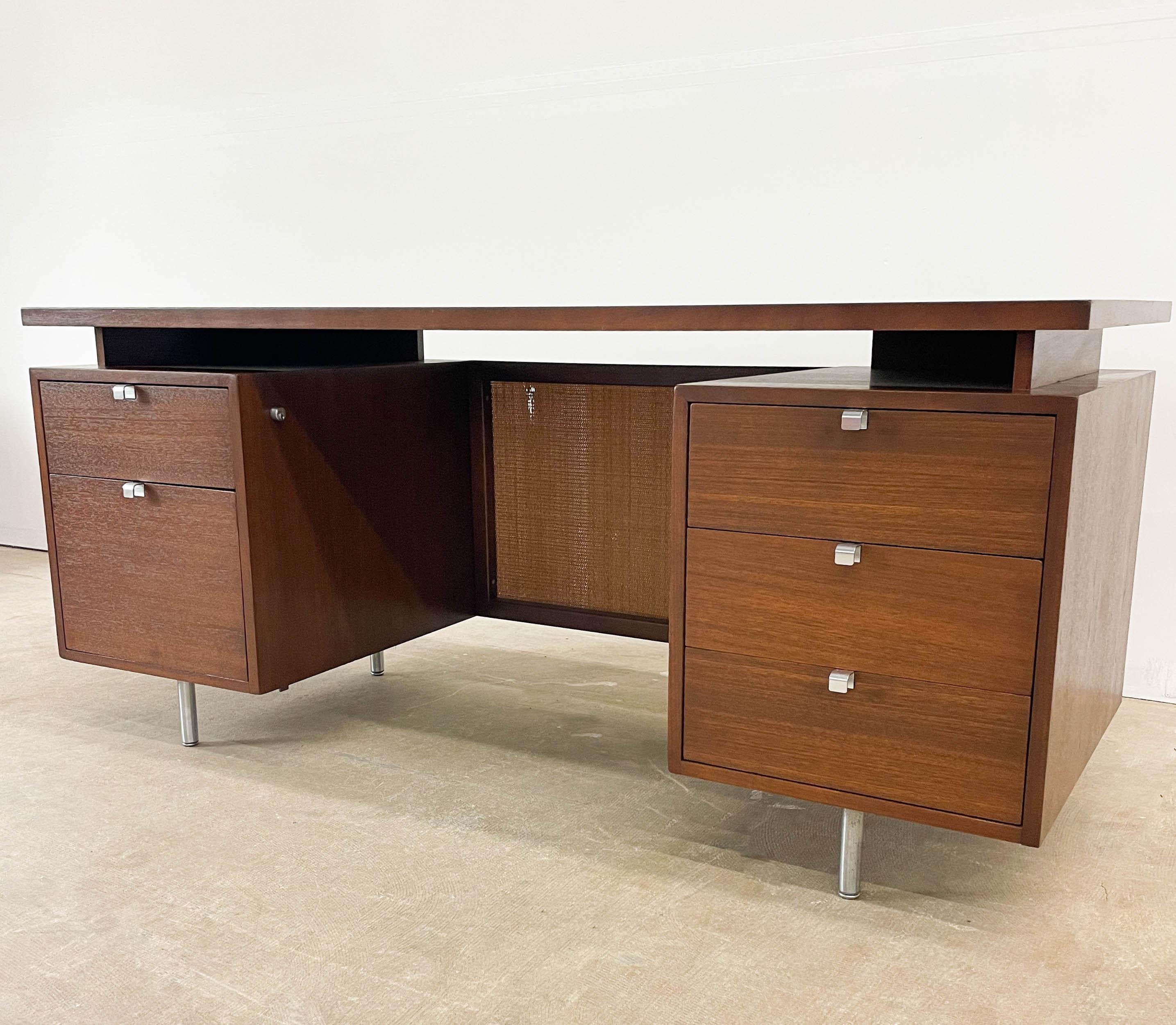 This is a stunning 1949 design from George Nelson for Herman Miller as part of the EOG Executive Office Group. The desk offers drawers on either side of the walnut pedestals as well as original chrome pulls and interior dividers in the drawers. The