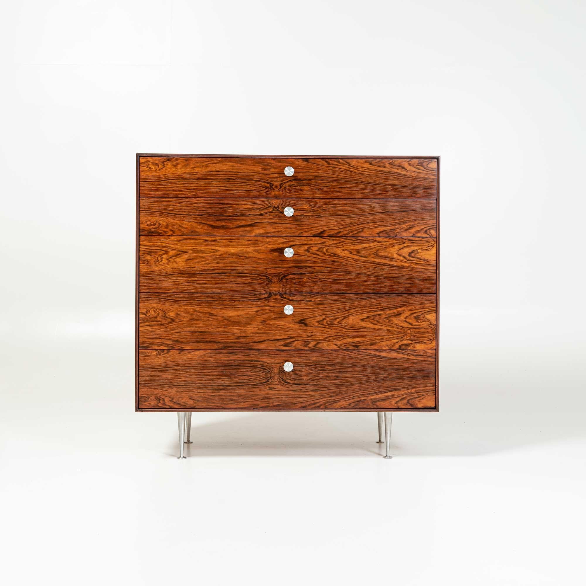 A rare George Nelson five drawer thin edge rosewood dresser, circa 1955. This stunning piece has dynamic rich rosewood graining and features five drawers with metal pulls and the iconic thin edge leg. Foil label inside drawer (George Nelson for